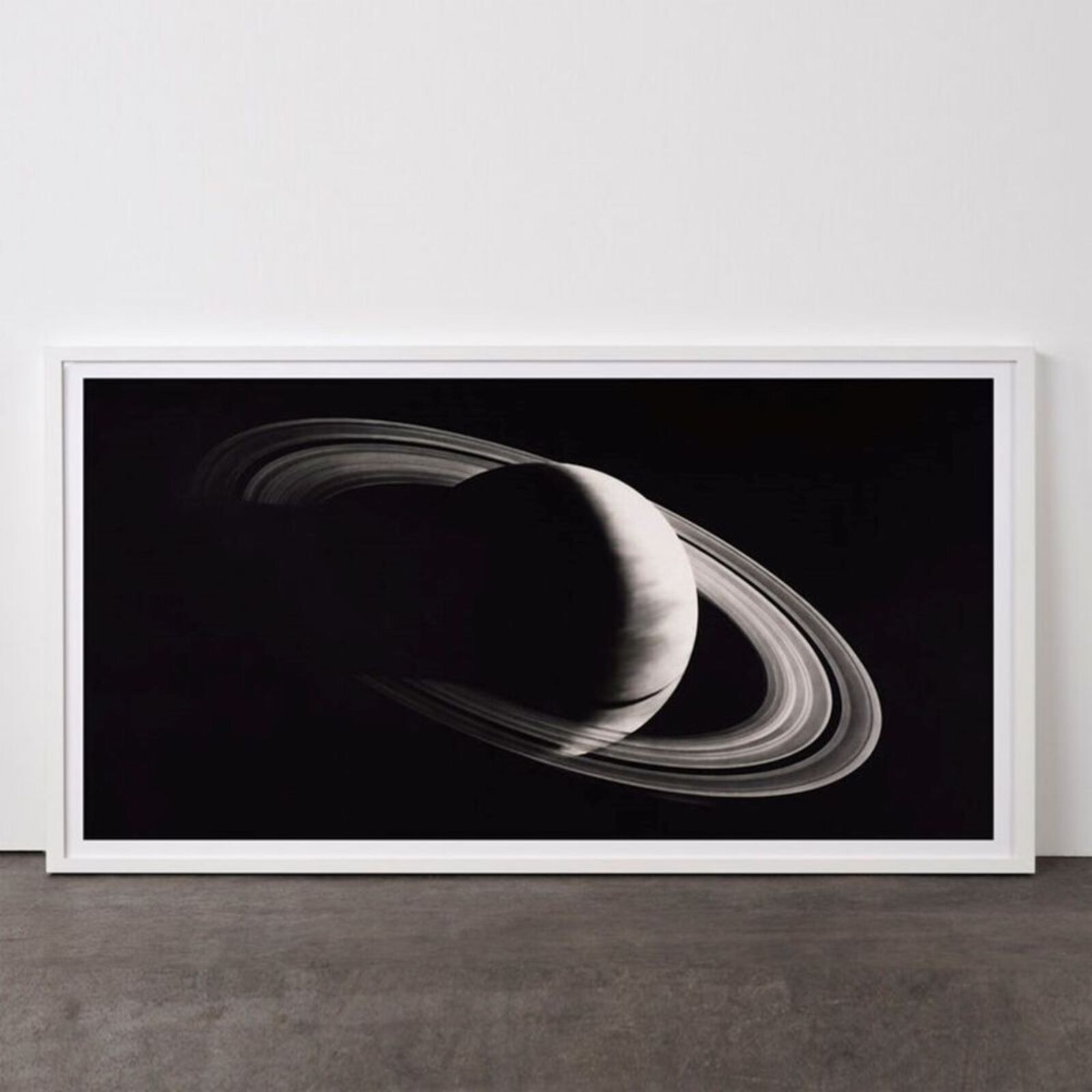 A black and white photo of a saturn in a white frame.