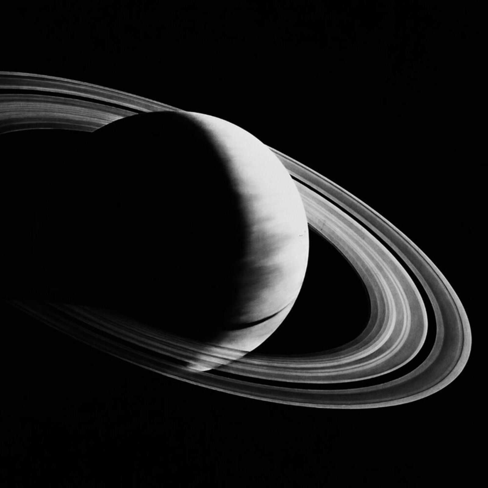 A black and white photo of a saturn in a white frame.