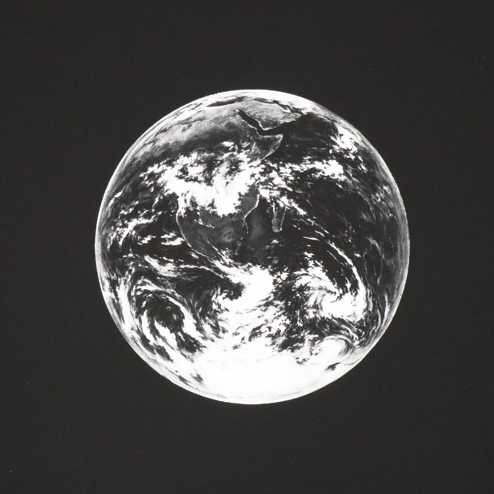 A black and white photo of the earth in the sky.