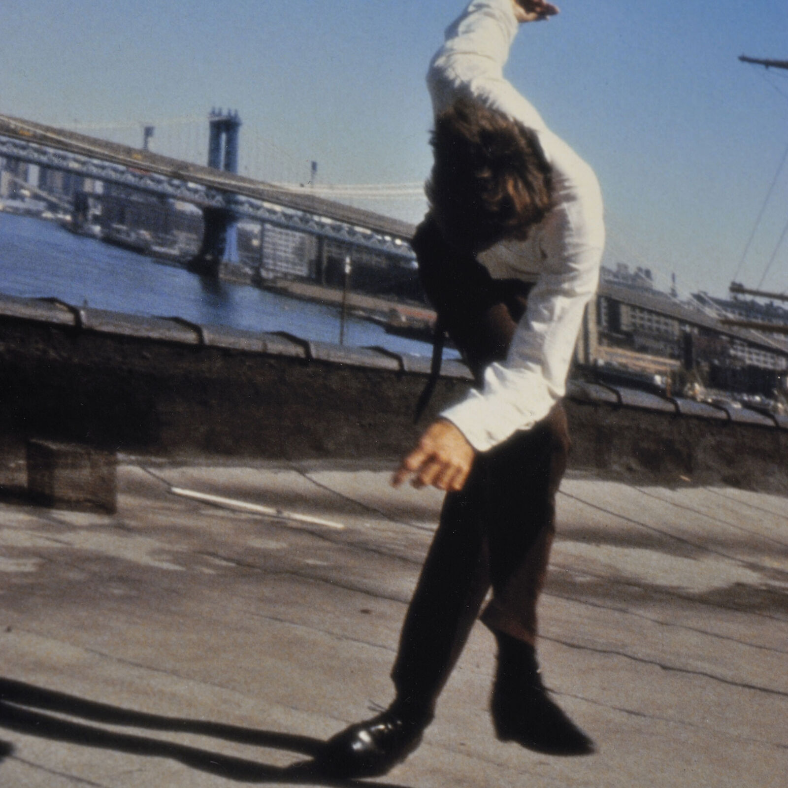 A dynamic street dance performance against an urban waterfront backdrop.