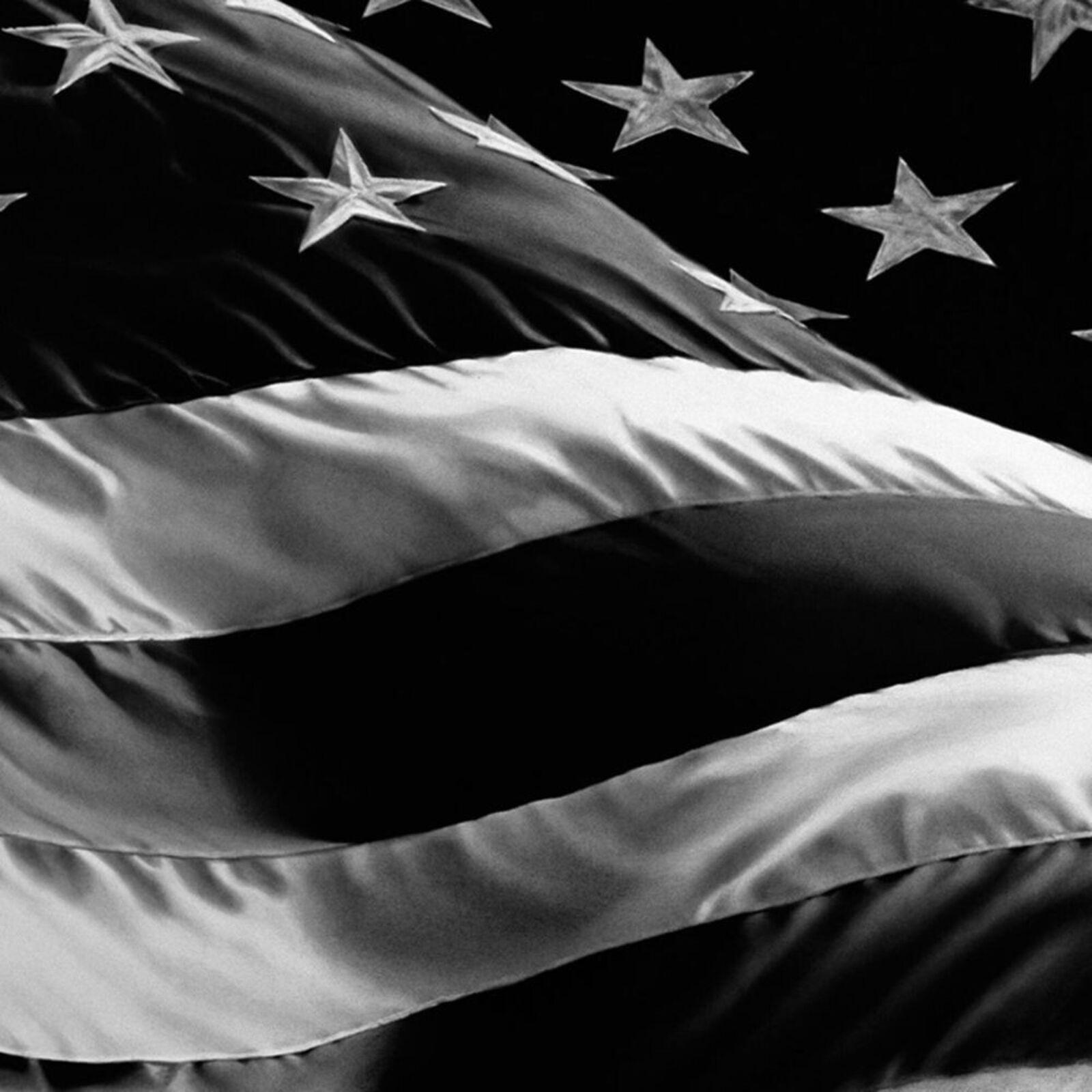 A black and white framed print of a waving flag with stars and stripes.