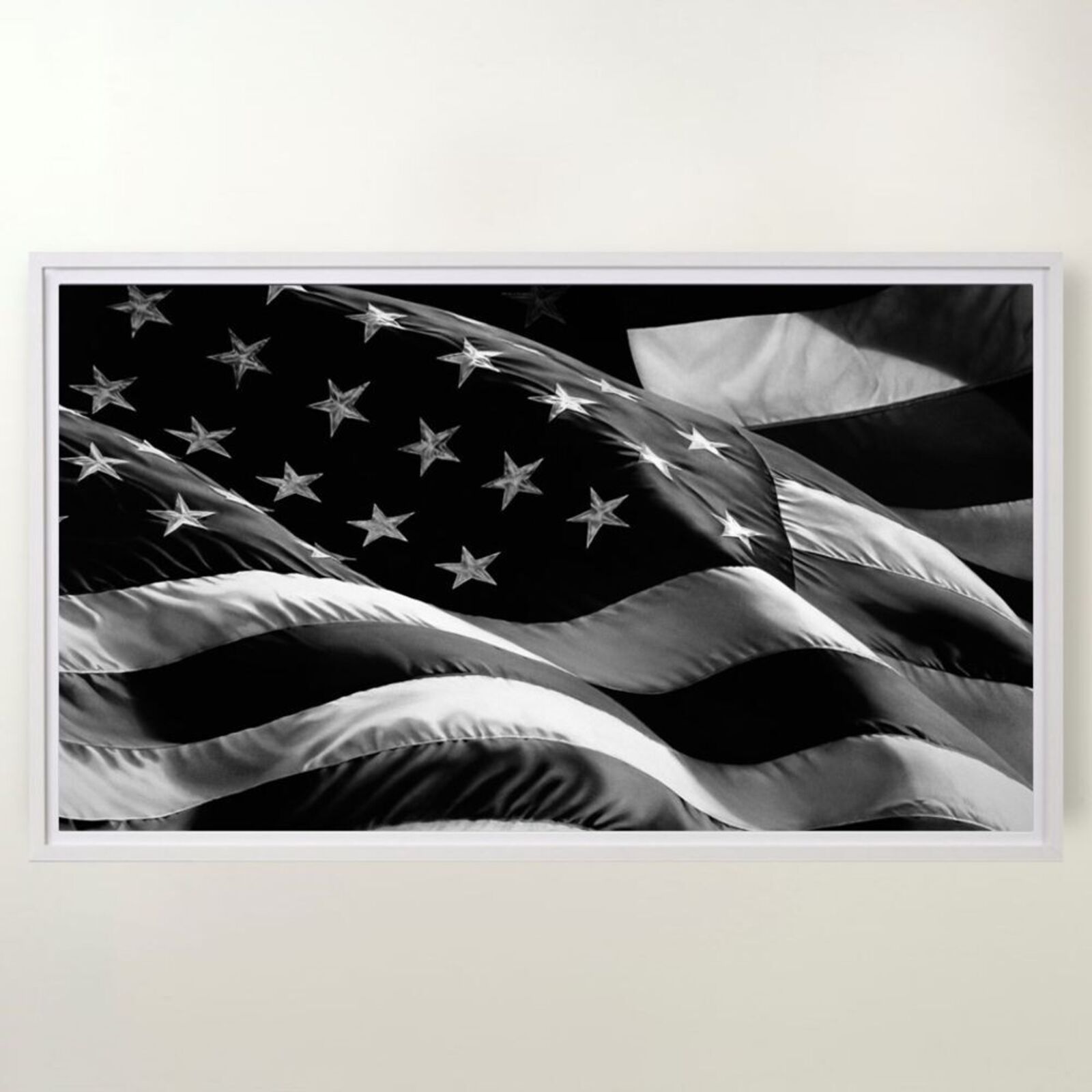 A black and white framed print of a waving flag with stars and stripes.