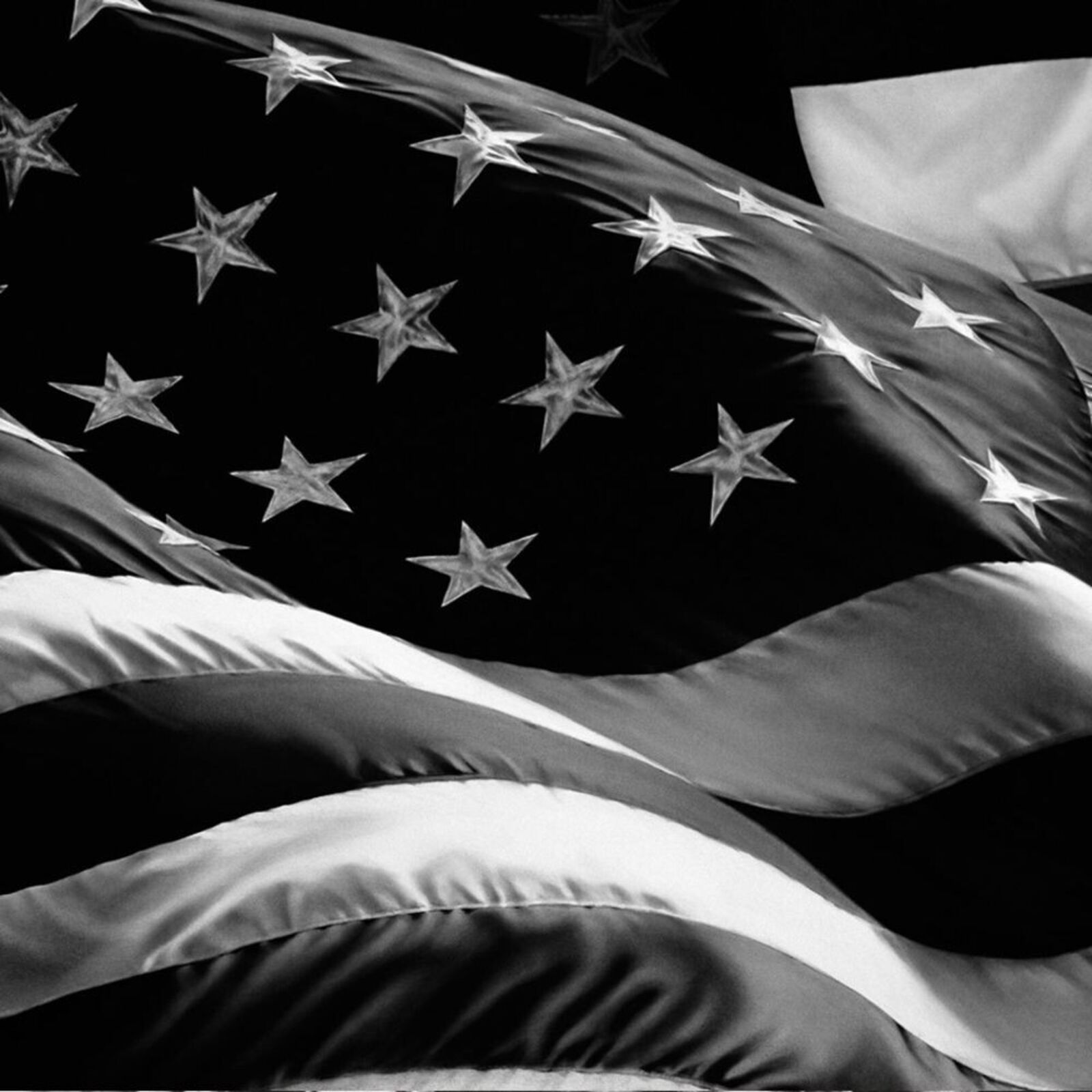 A black and white framed print of a waving flag with stars and stripes.