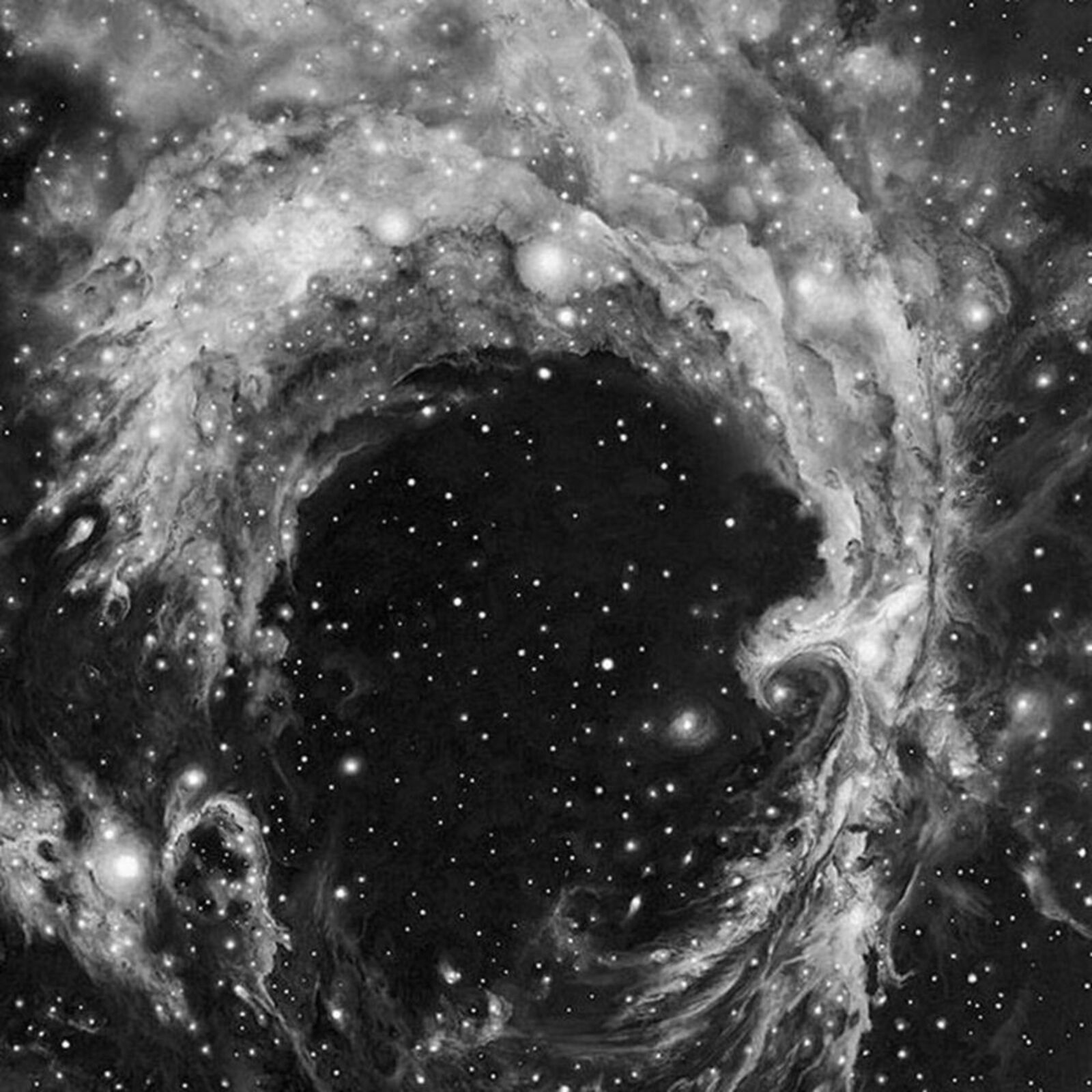 A framed black-and-white print of a swirling cosmic nebula against a minimalist interior wall.