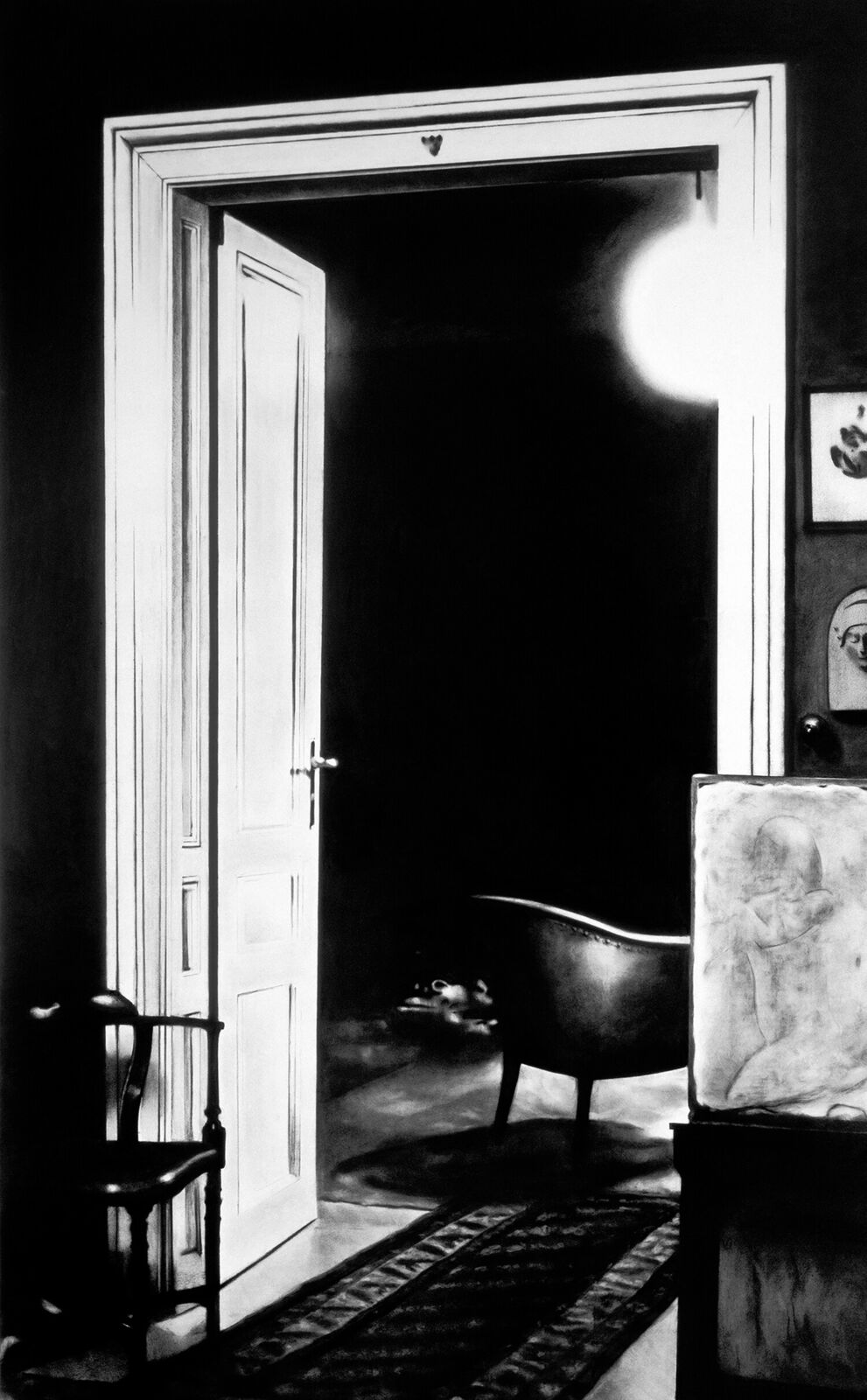 A gallery wall of black and white framed photographs showcasing interior details.