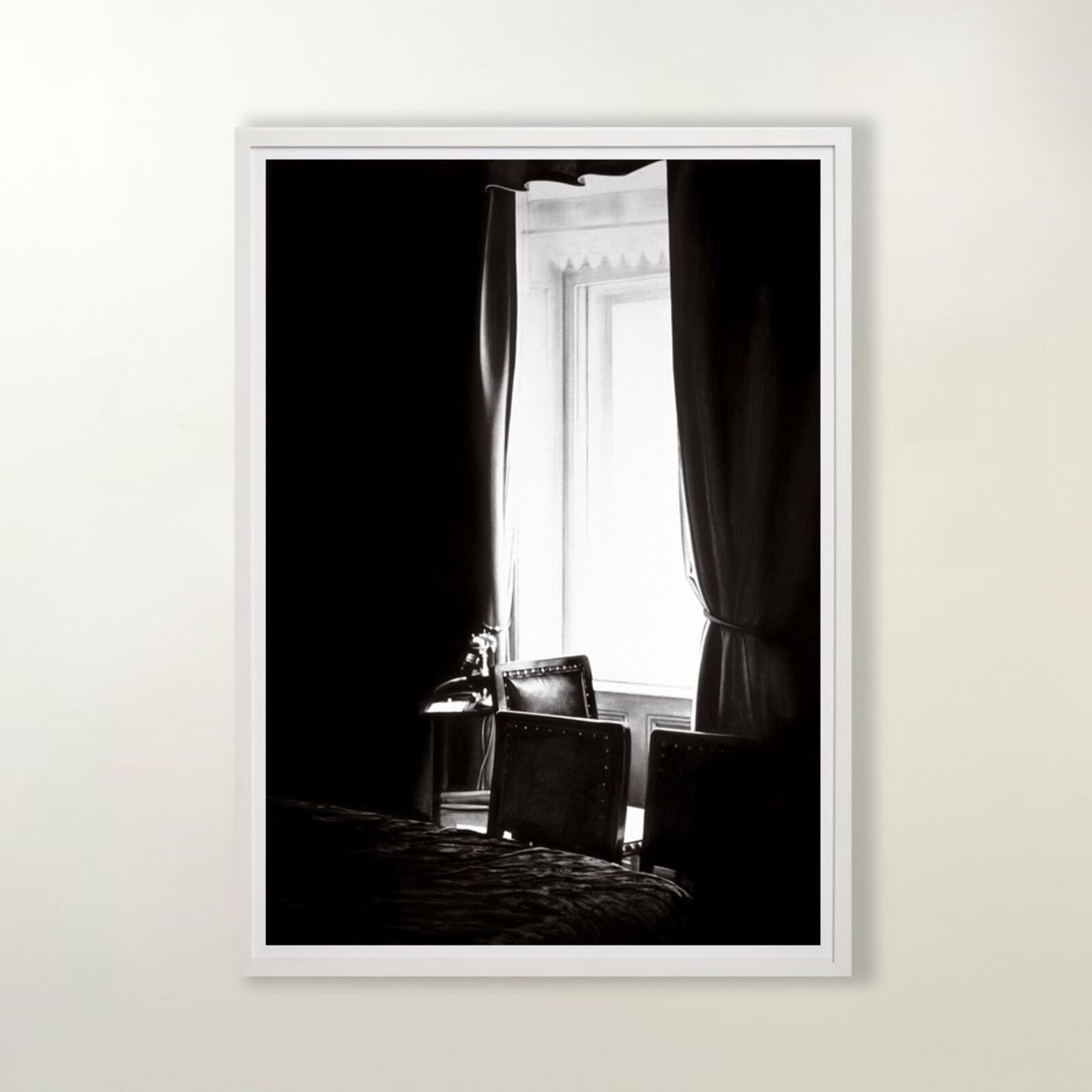 A gallery wall of black and white framed photographs showcasing interior details.