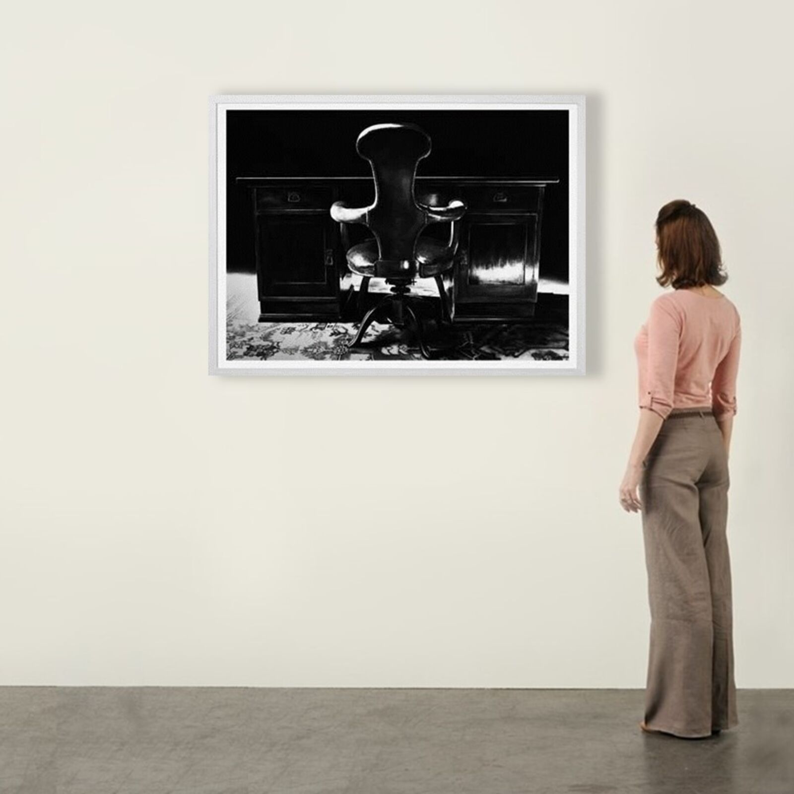 A gallery wall of black and white framed photographs showcasing interior details.