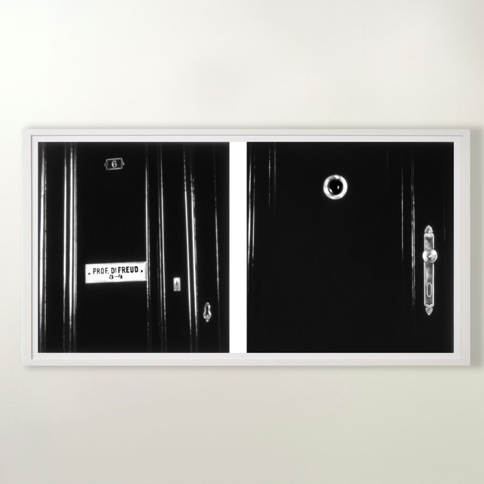 A gallery wall of black and white framed photographs showcasing interior details.