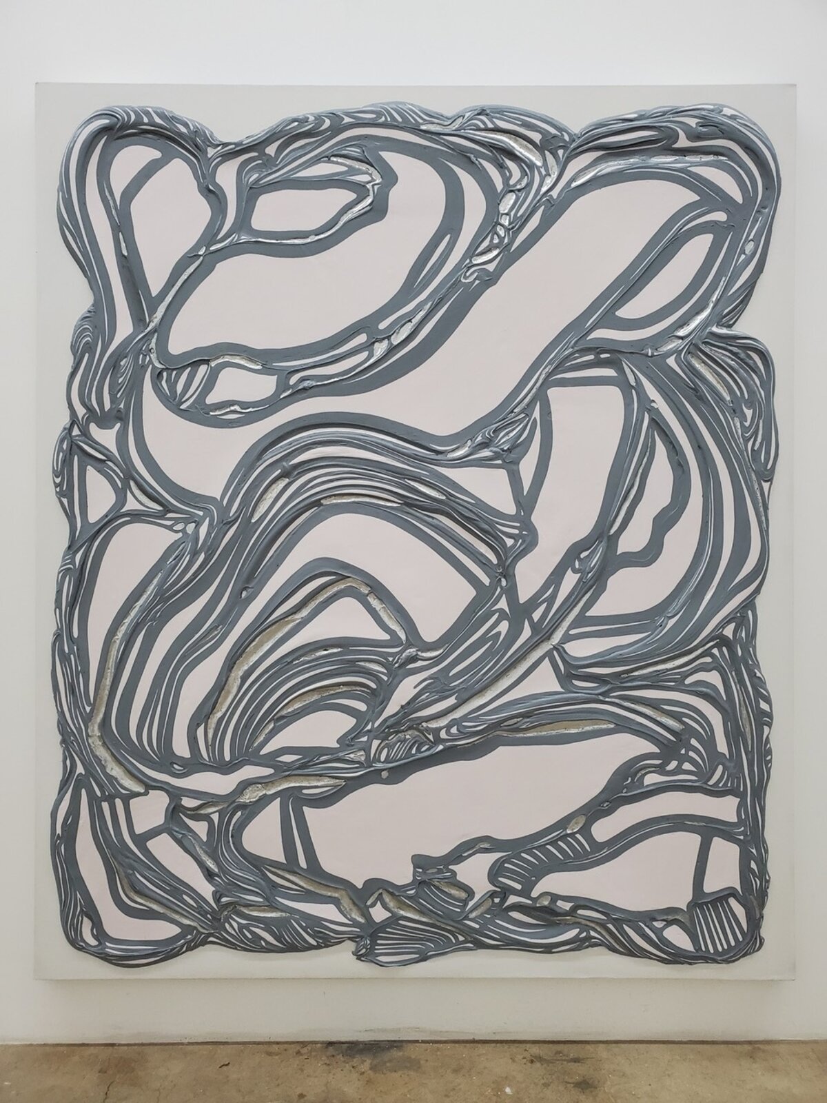 A textured abstract relief featuring a network of grey, ribbon-like forms against a pale background.