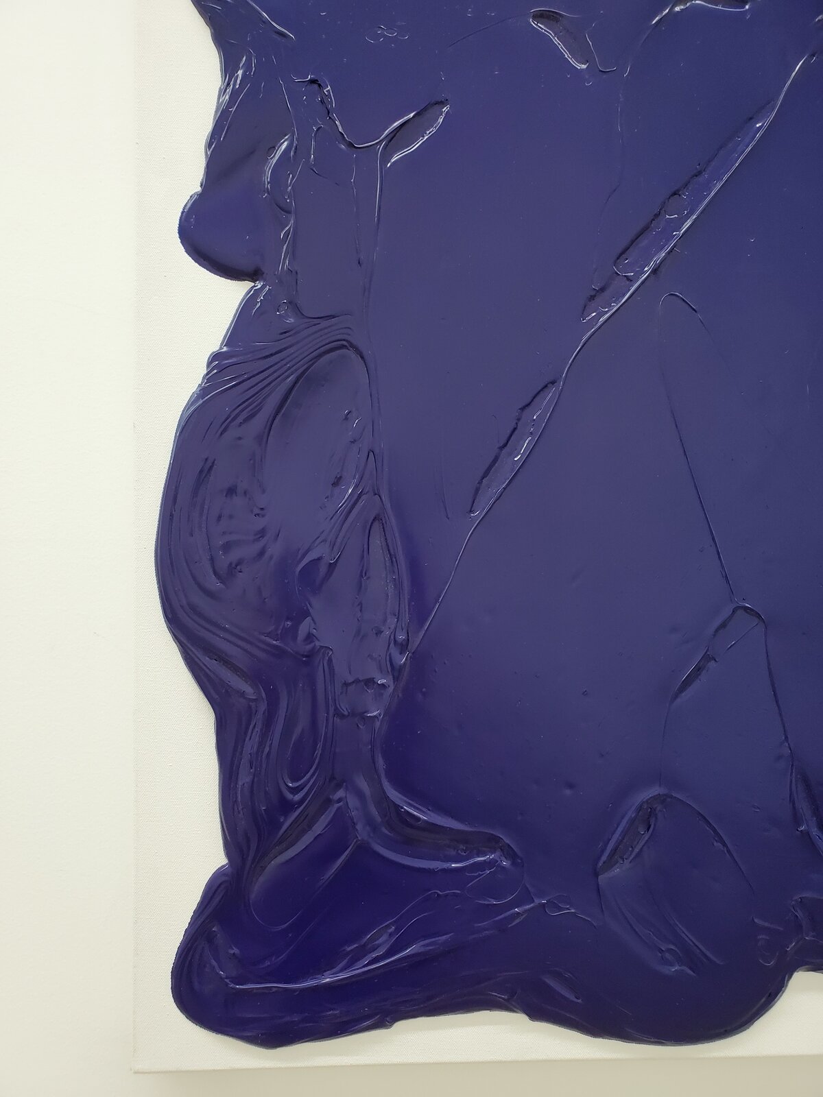 A thick, dark blue abstract form on a white canvas.