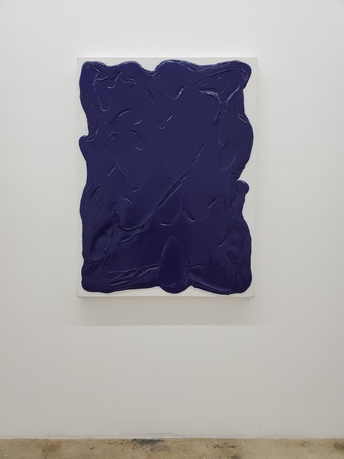 A thick, dark blue abstract form on a white canvas.