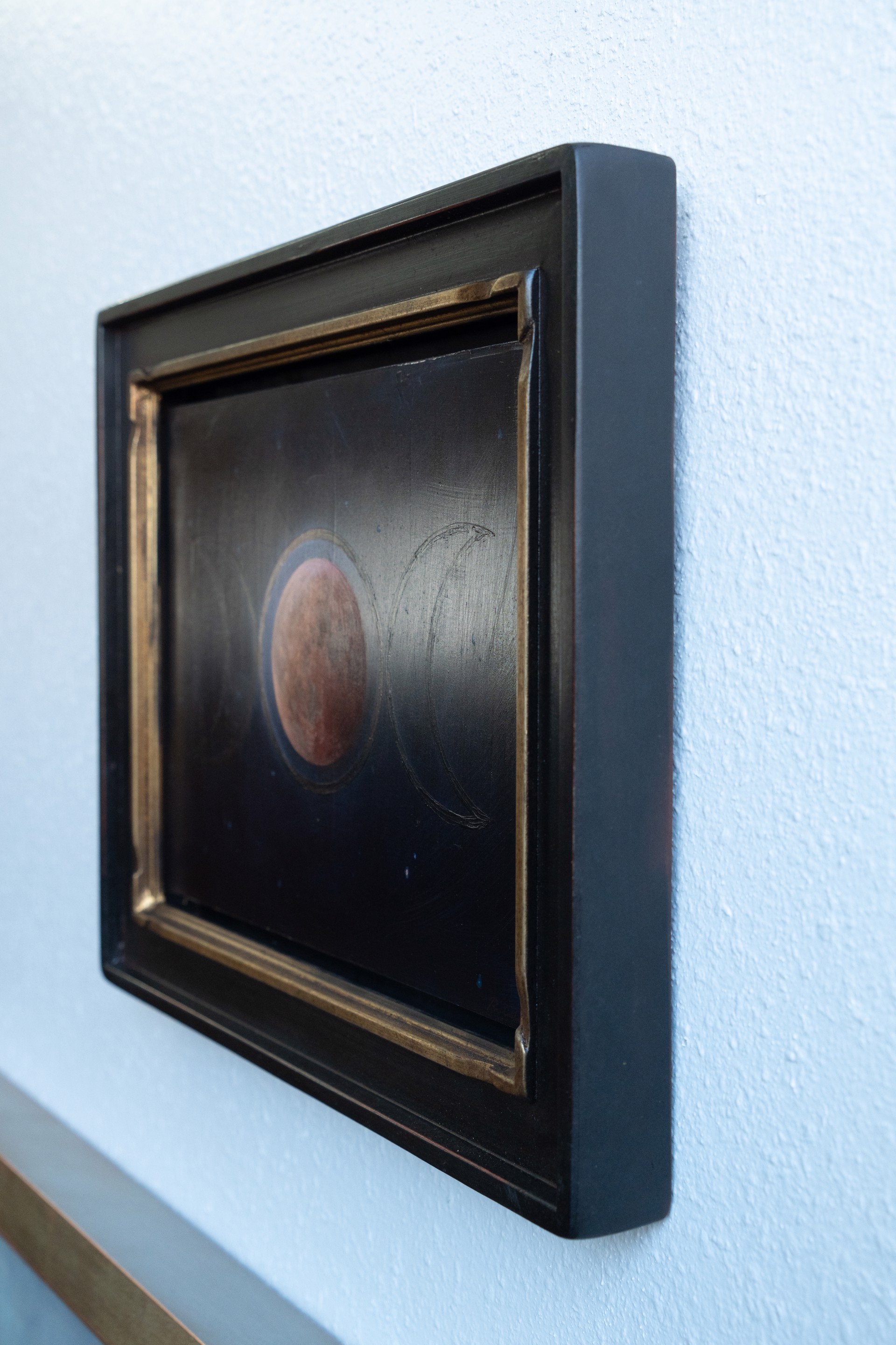 A painting of three phases of the moon in the night sky.