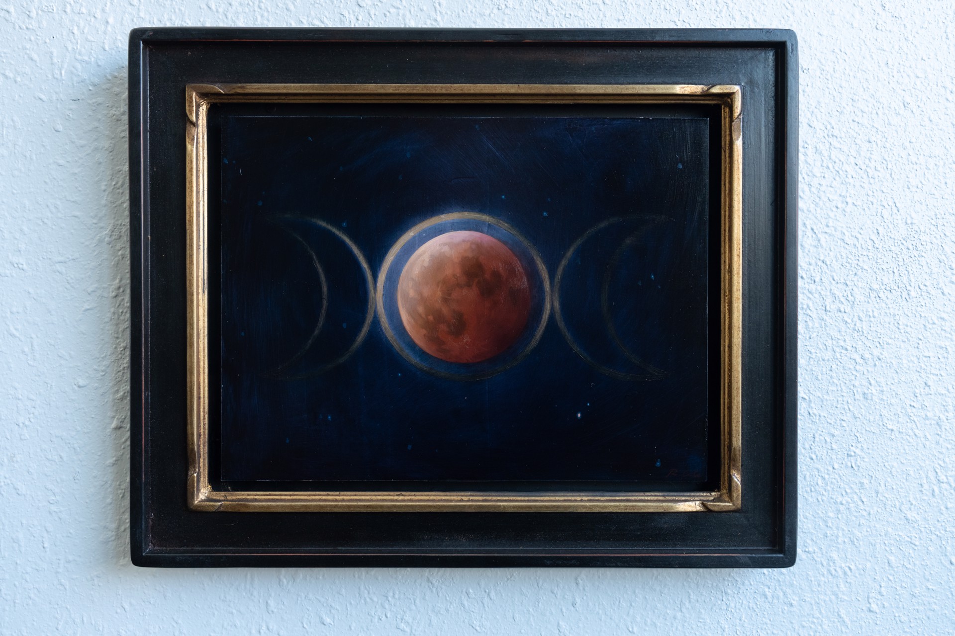 A painting of three phases of the moon in the night sky.