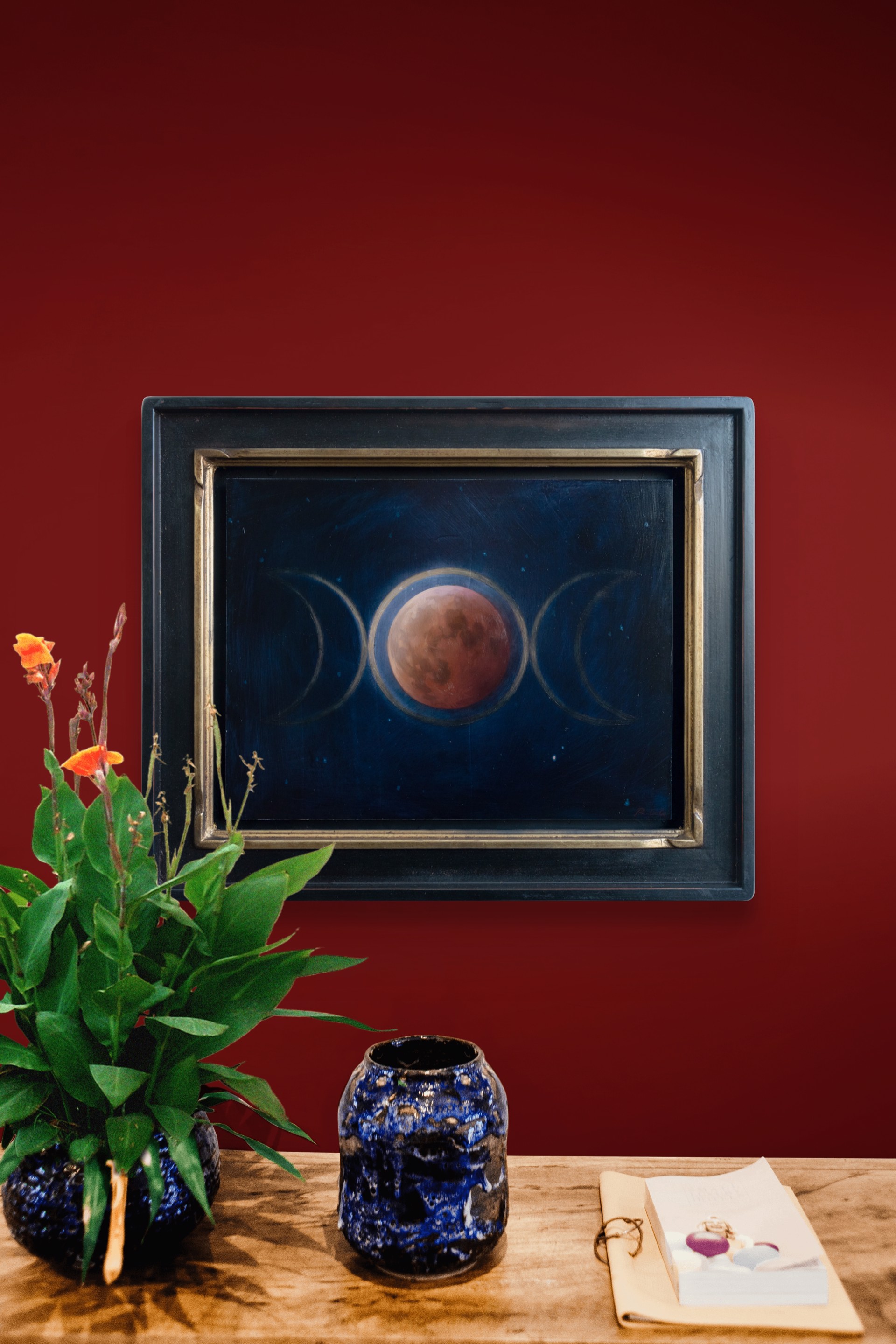 A painting of three phases of the moon in the night sky.