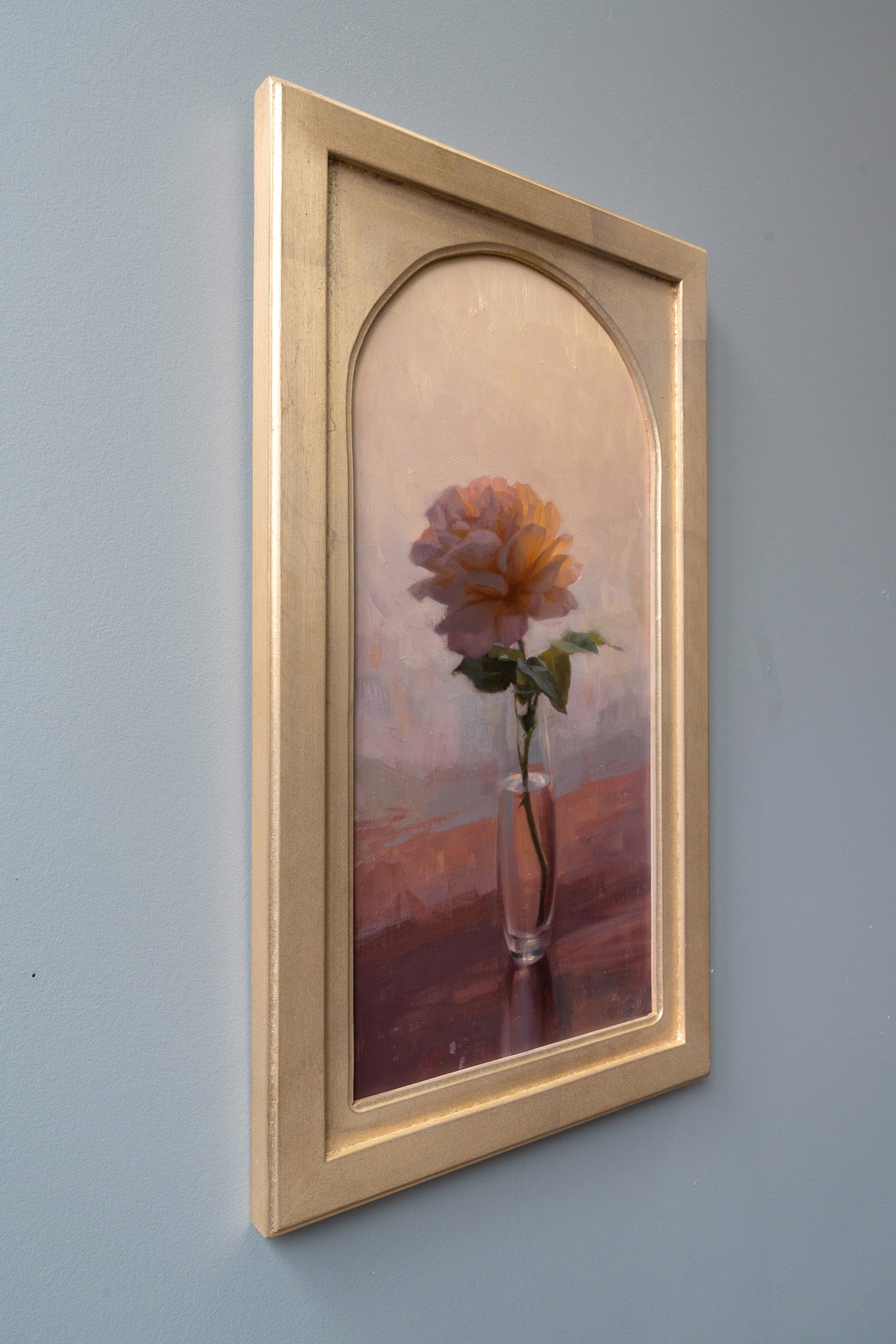 A soft, impressionistic still life of a single rose in a glass vase.