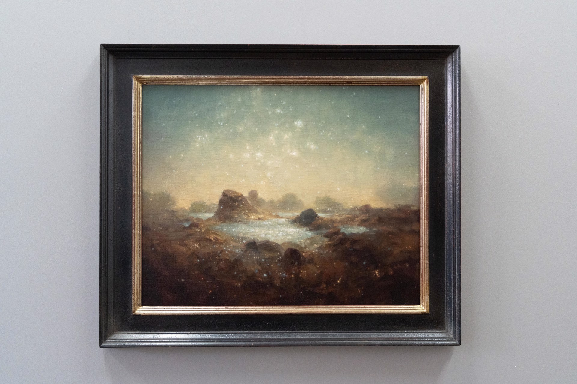 A painting of a rocky landscape with a starry sky.