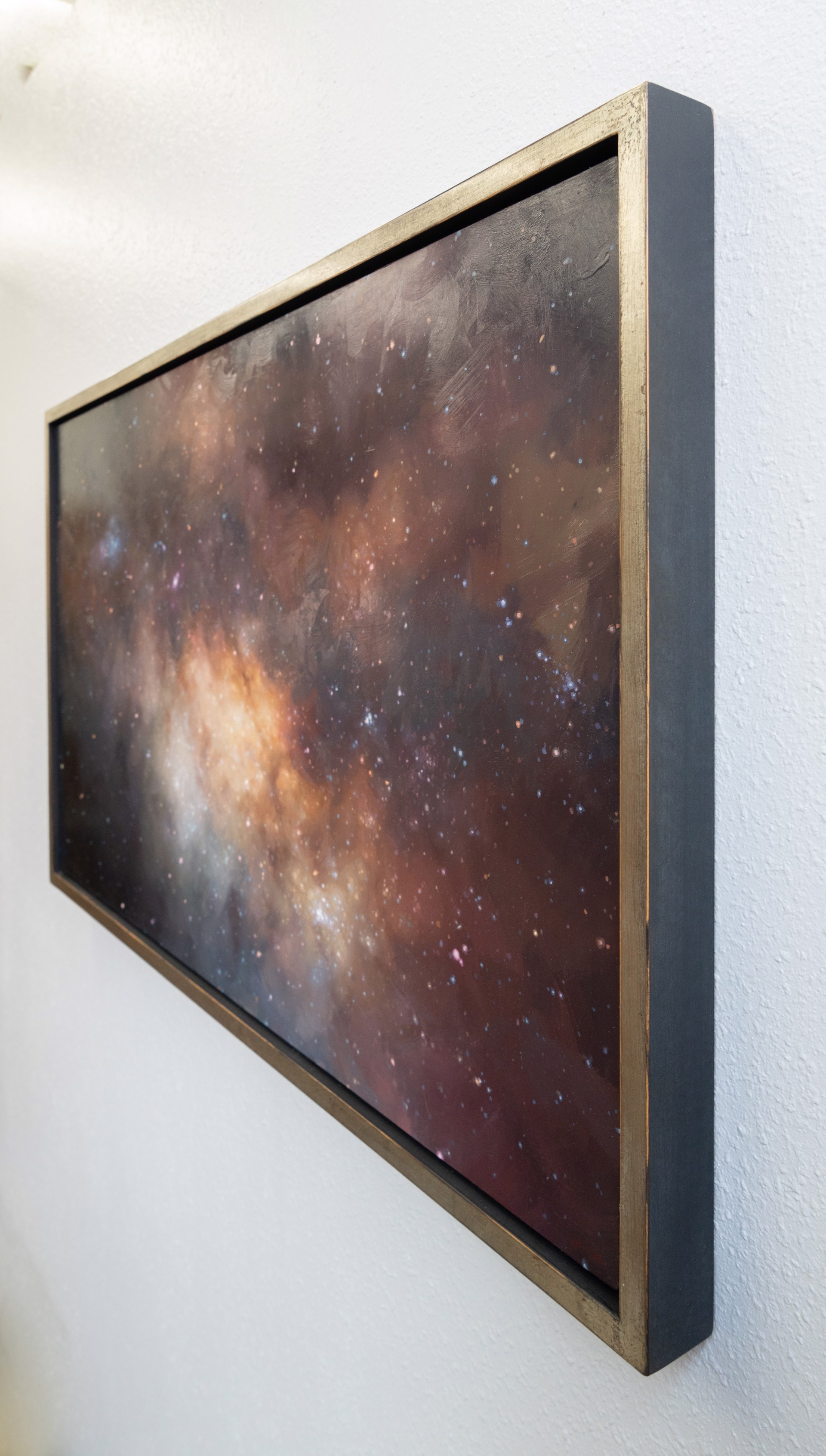 A cosmic nebula scene featuring a glowing central cloud surrounded by dark space and scattered stars.