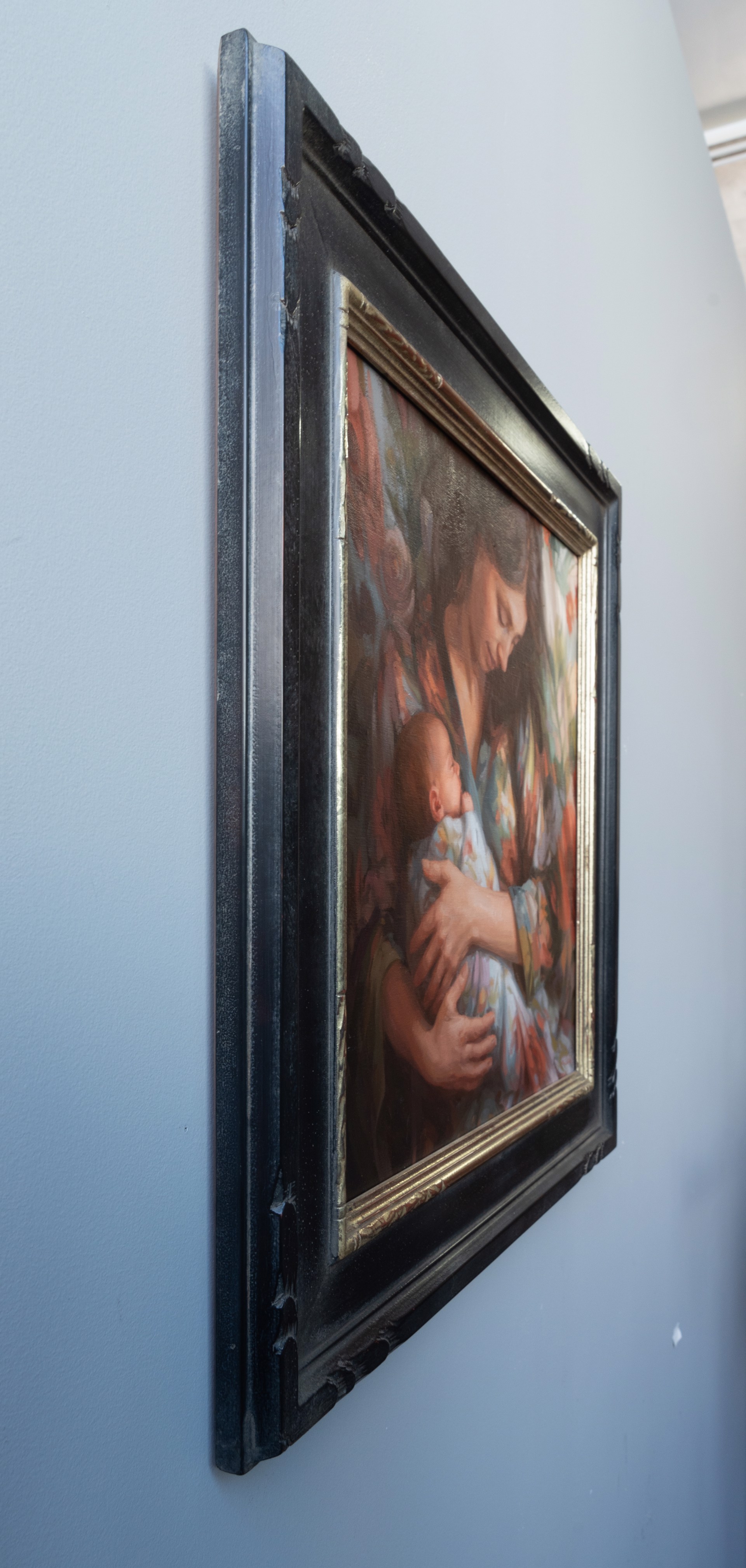 A painting of a woman holding a baby in her arms.