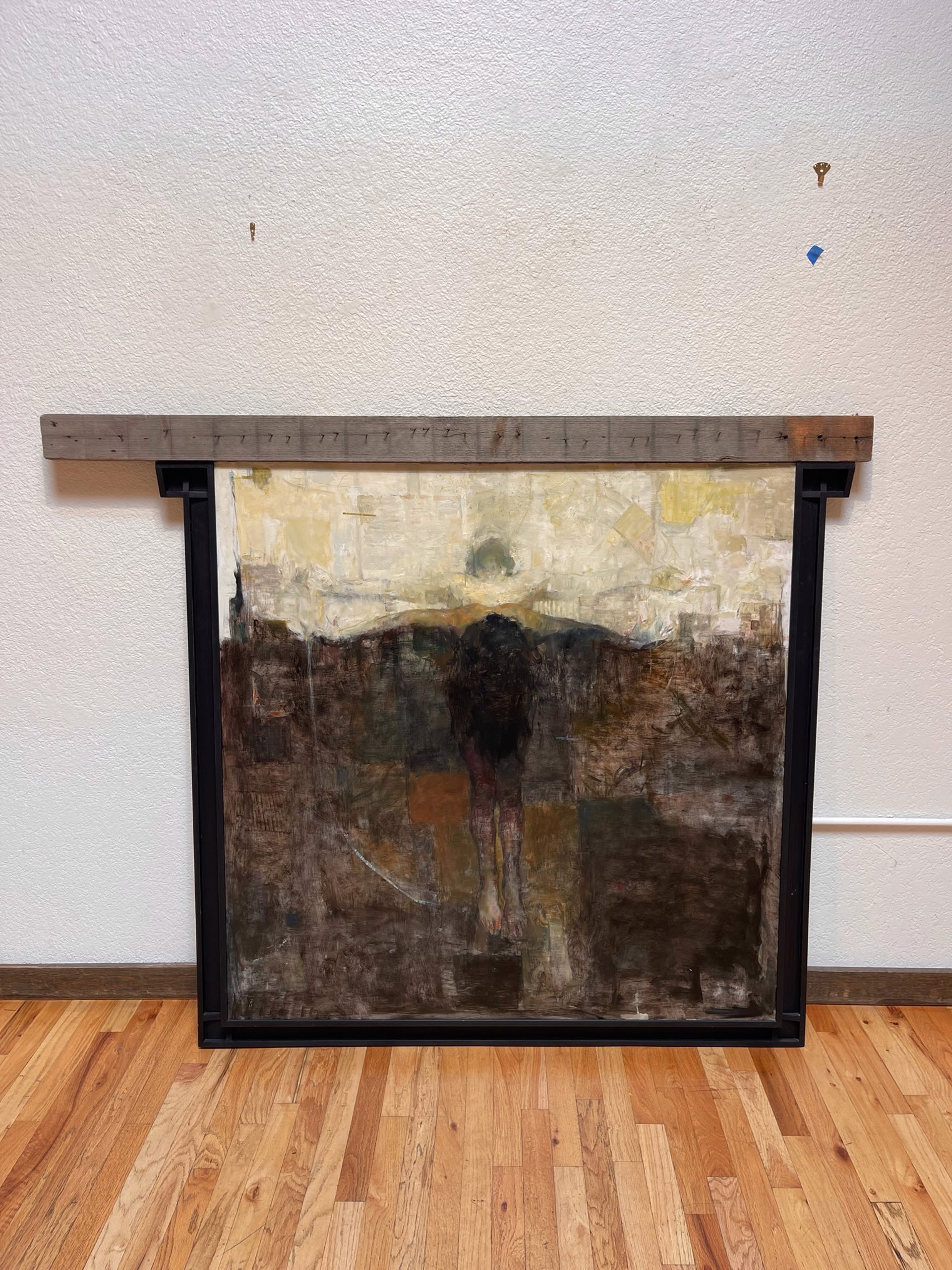 A dark, textured painting of a solitary figure standing in shadow against a pale horizon.