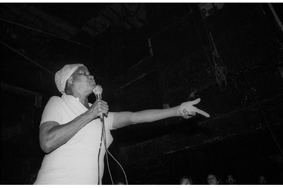 A woman holding a microphone in front of a crowd.