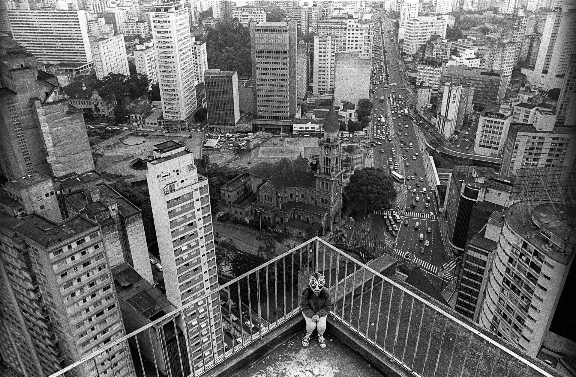 A person standing on a balcony overlooking a city.