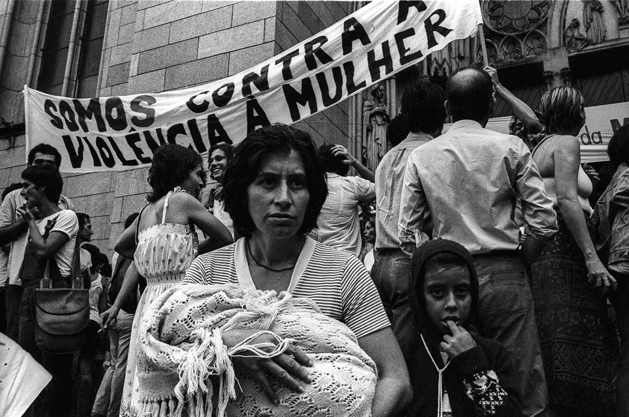 A group of people standing in front of a building holding a banner.