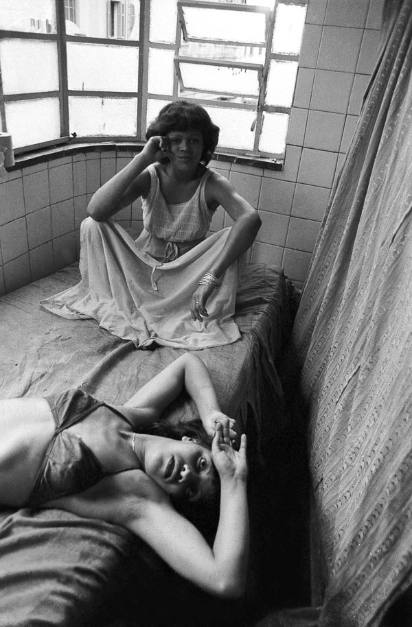 Two women laying on a bed in a room.