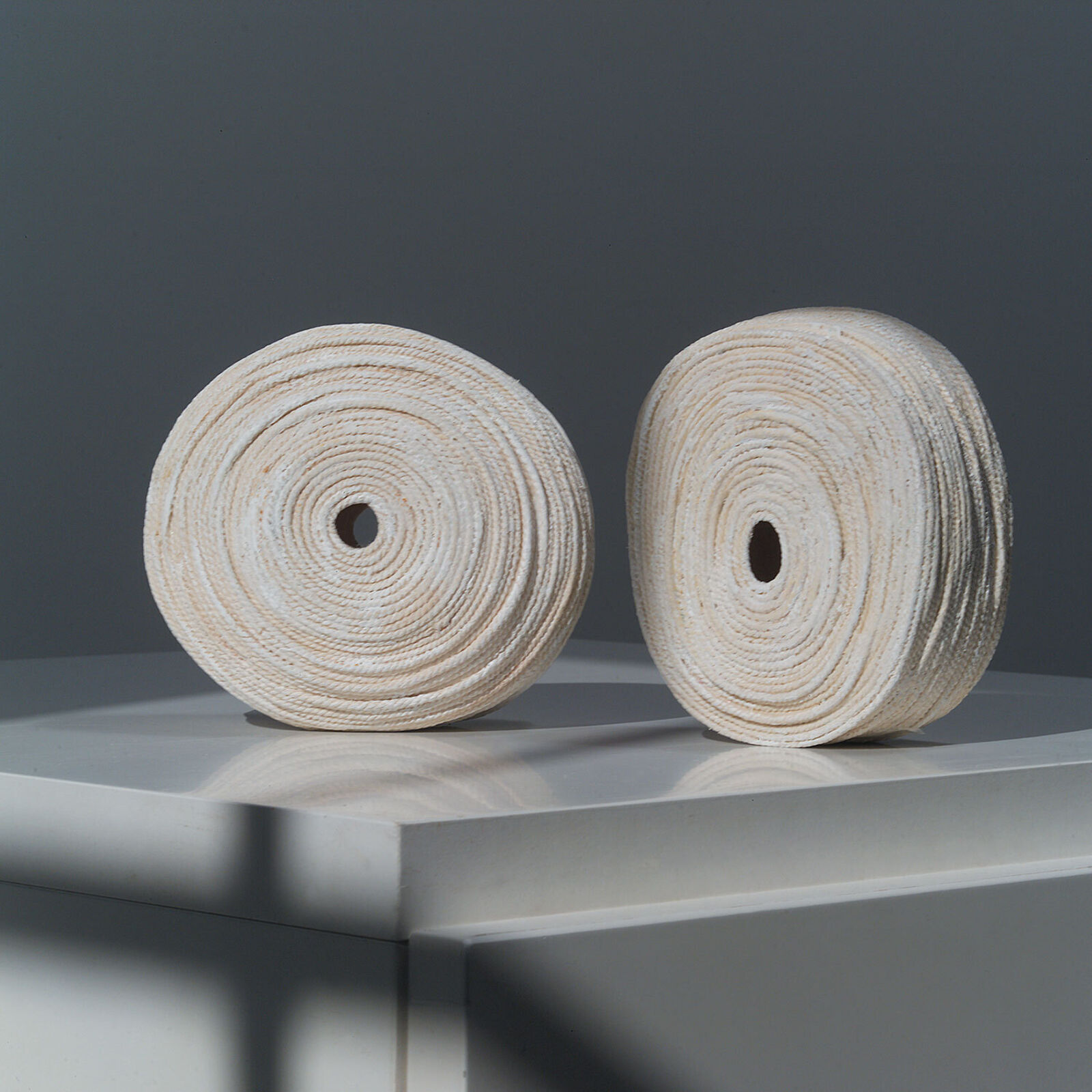 Two rolls of toilet paper sitting on top of a wooden shelf.