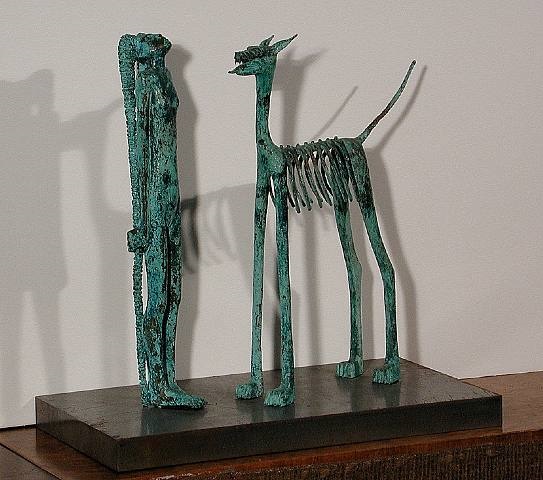 a bronze sculpture of a dog and a man on a wooden base