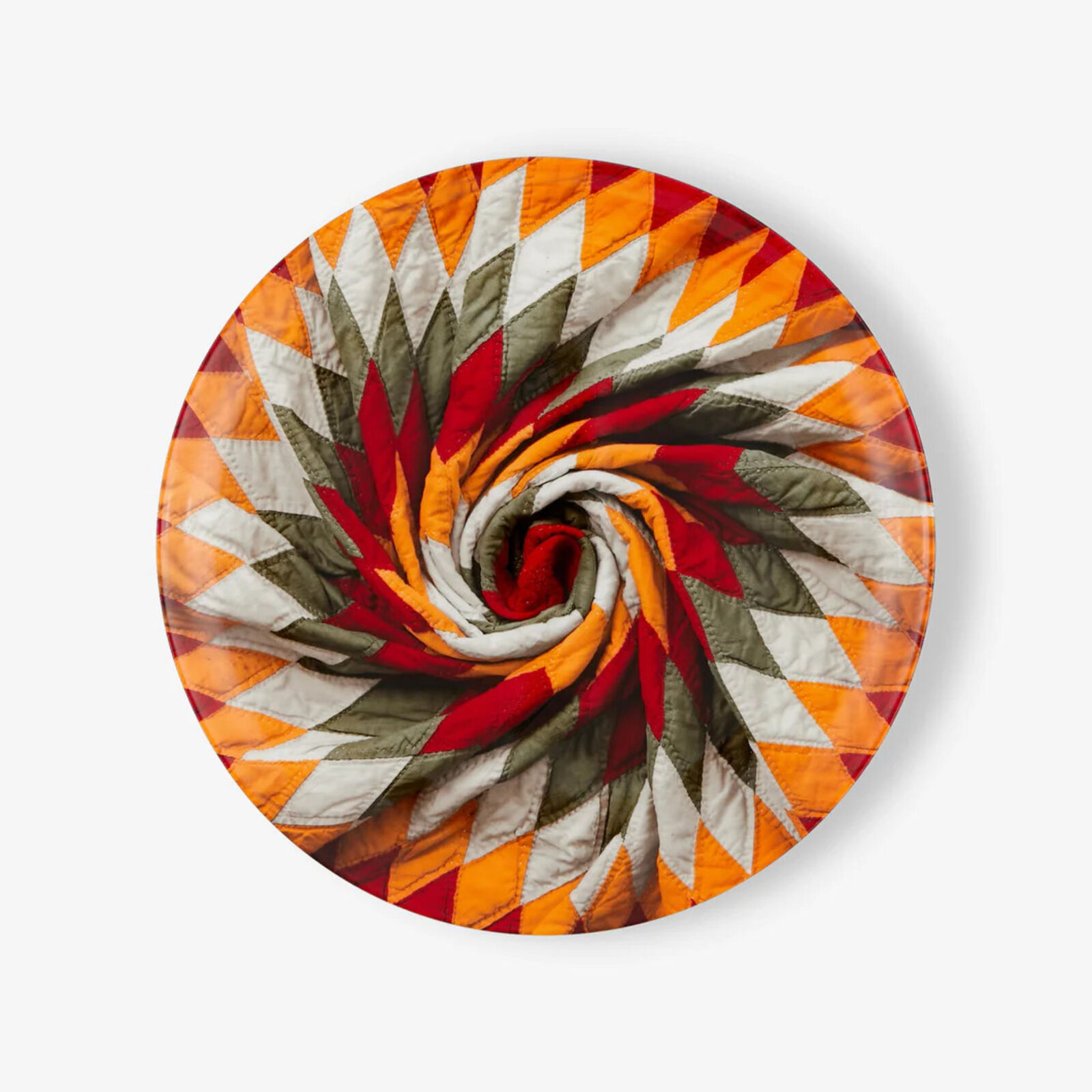A circular quilt on a white background. 