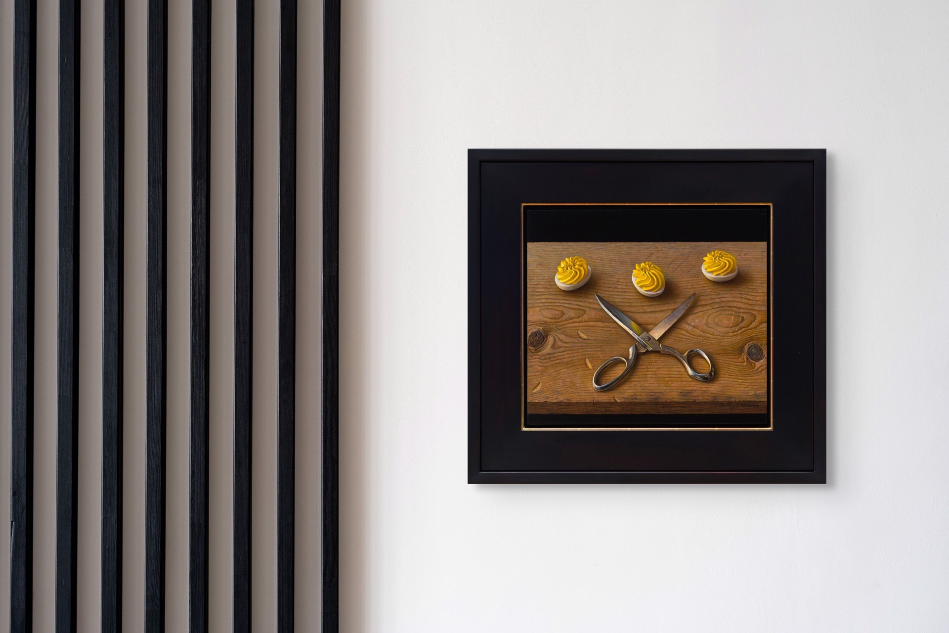 A still life painting featuring crossed silver scissors and three white discs topped with yellow frosting on a wooden surface.