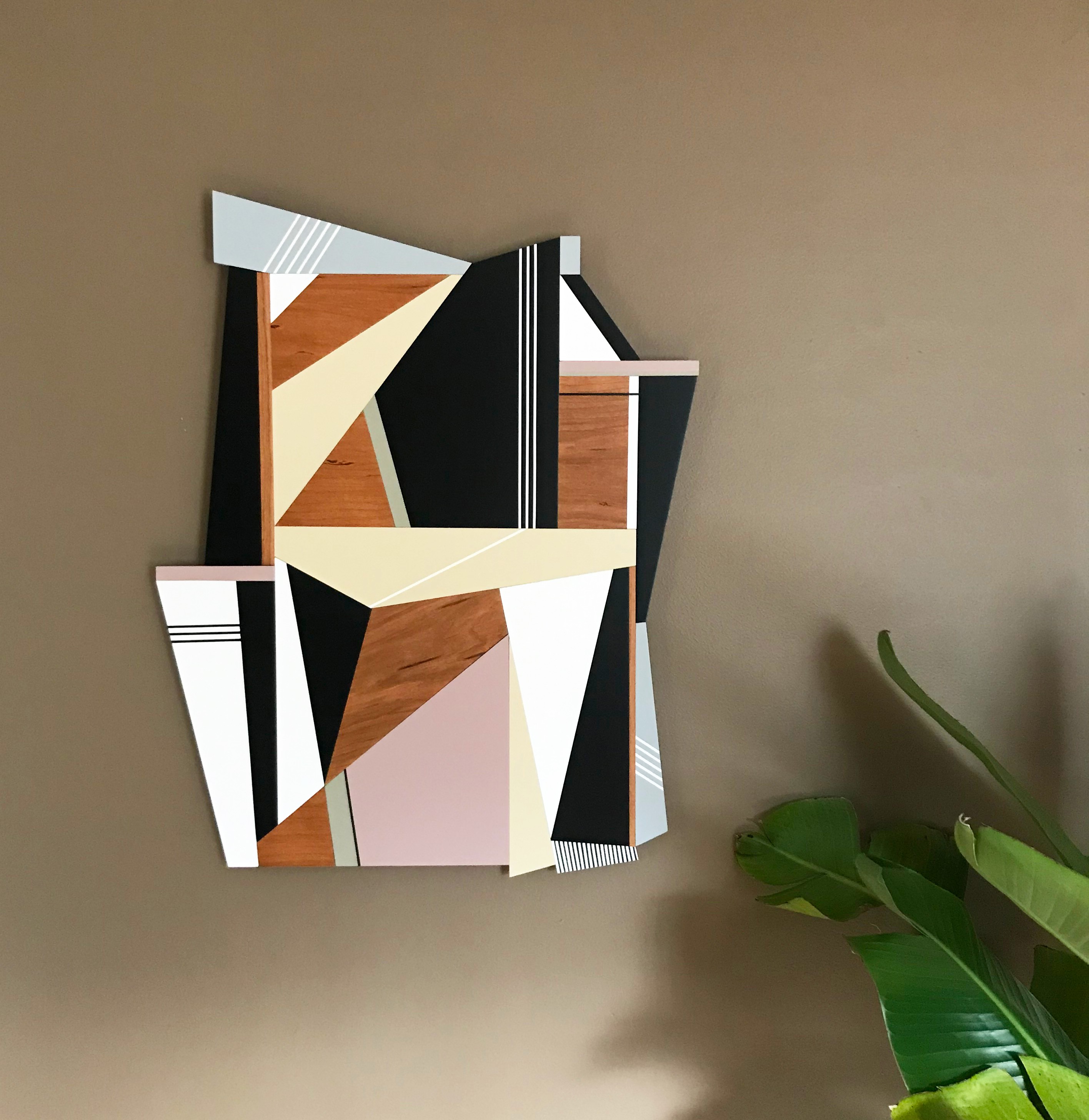 A geometric abstract composition featuring layered wooden and painted panels in a dynamic, fragmented arrangement.