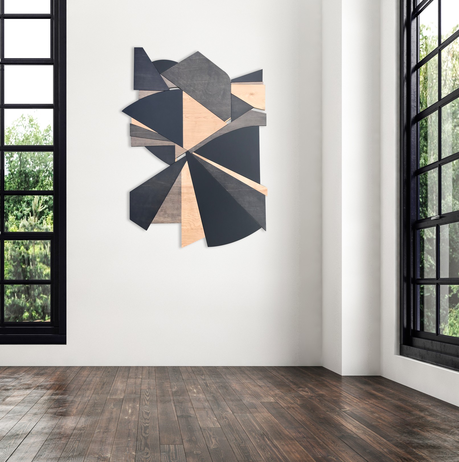 A geometric wooden sculpture composed of layered triangular panels in black, light wood, and dark wood resting on asphalt.