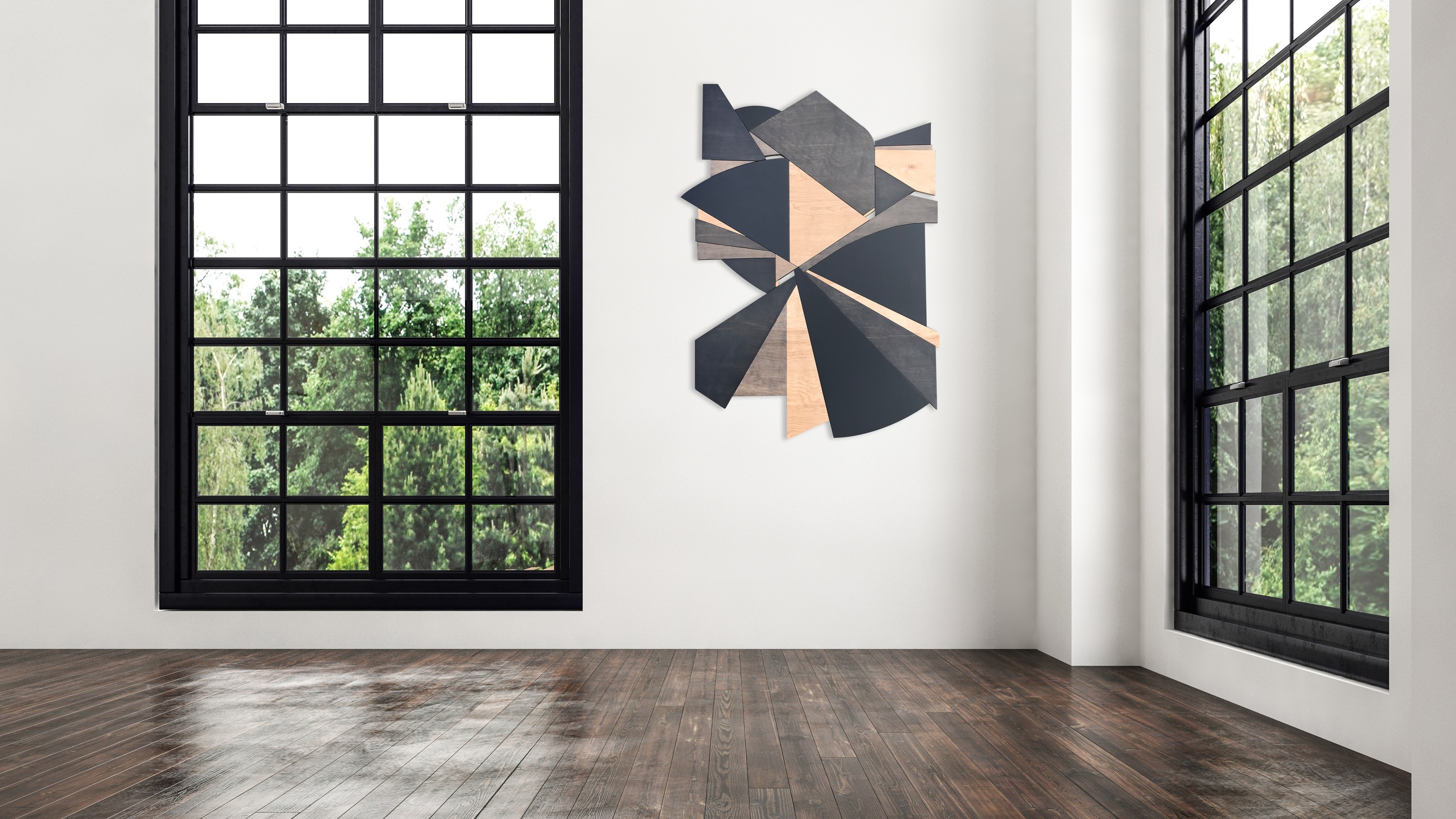 A geometric wooden sculpture composed of layered triangular panels in black, light wood, and dark wood resting on asphalt.