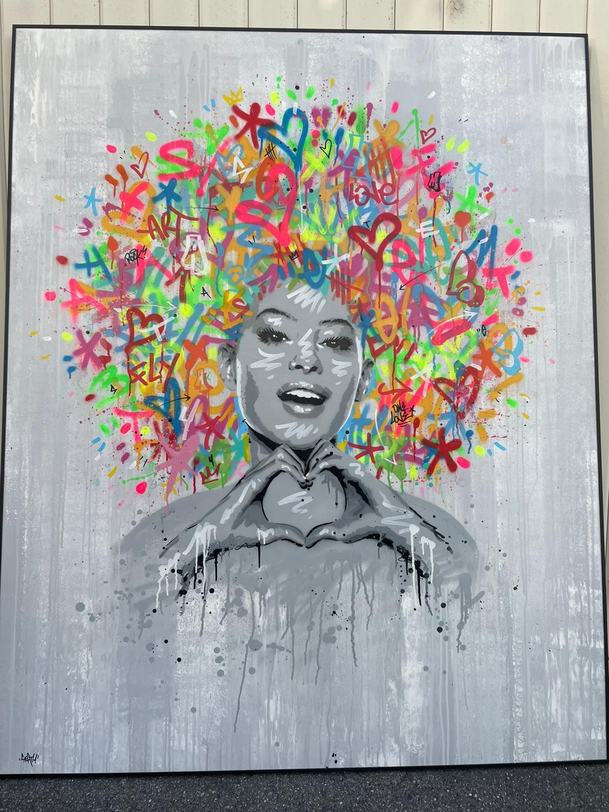 A portrait of a figure with a vibrant, graffiti-style explosion of colorful symbols and text erupting from their head.