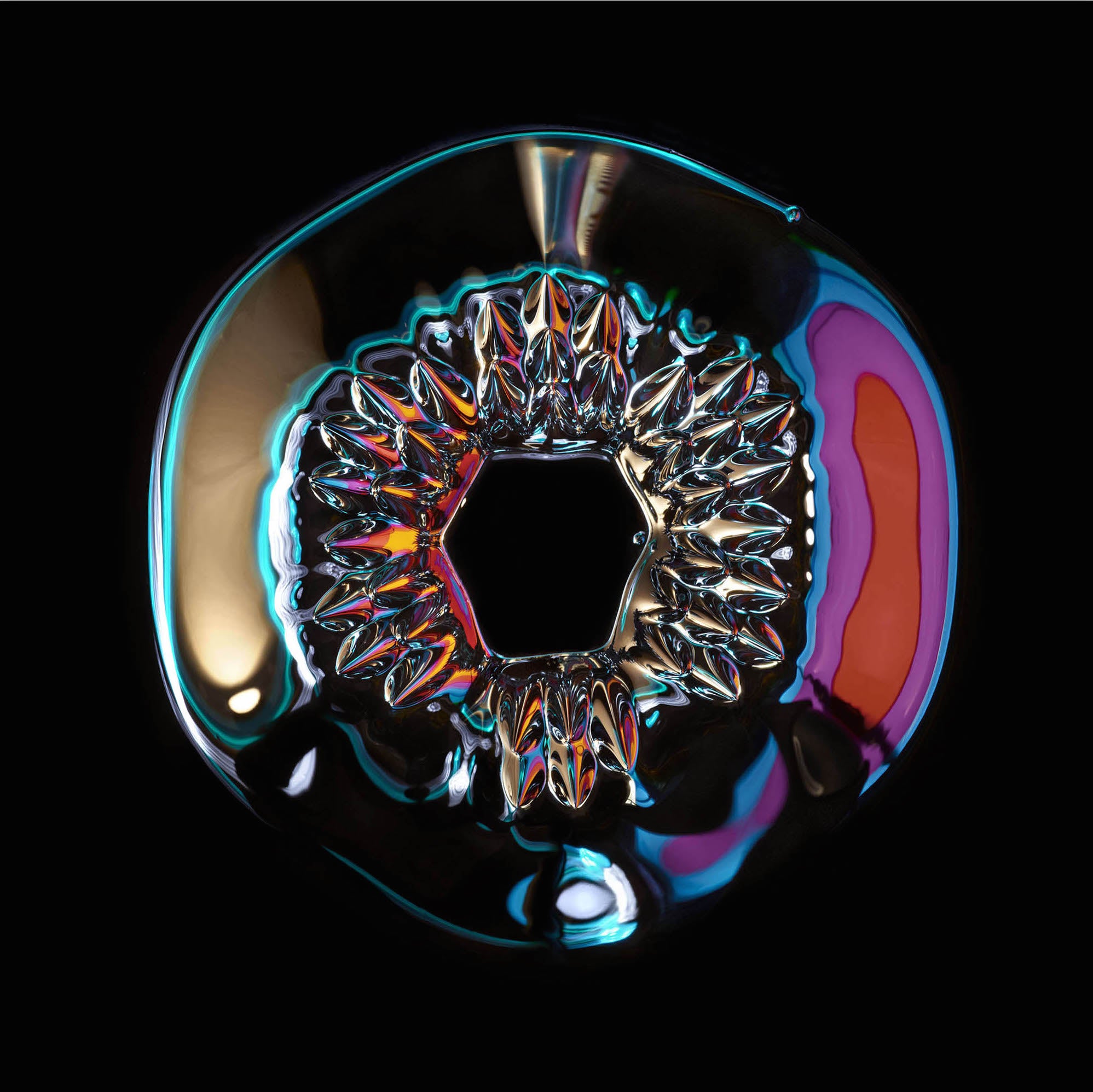 A close up of a colorful object on a black background.