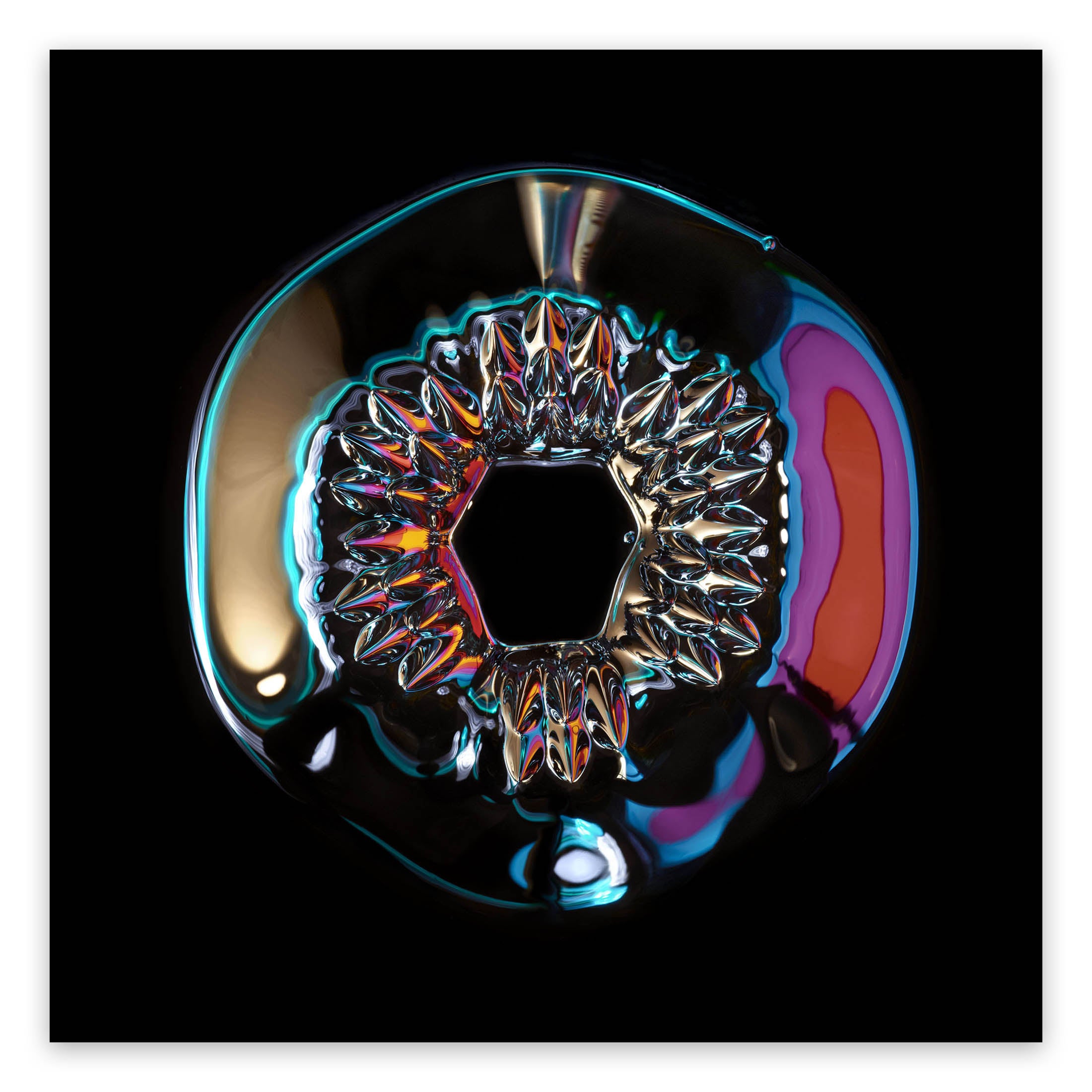 A close up of a colorful object on a black background.