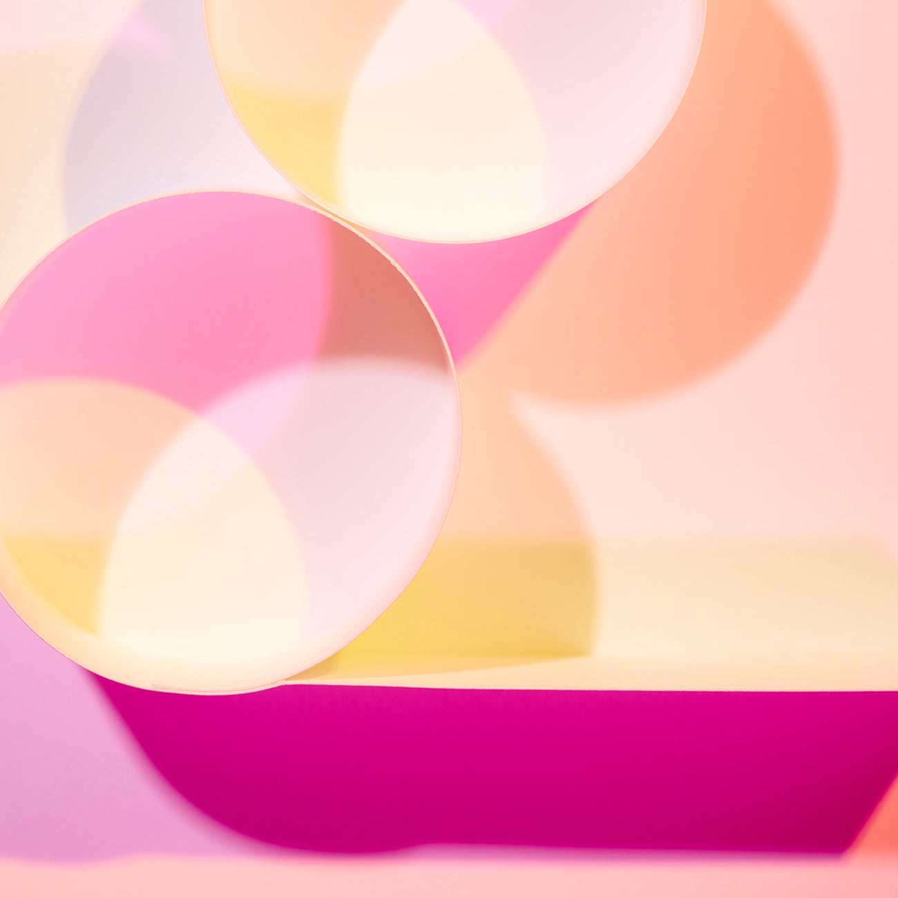 A pink and yellow abstract painting with circles on a pink background.