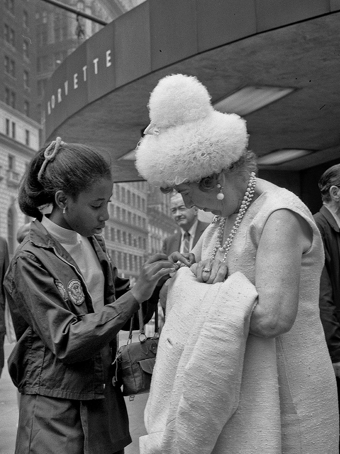 A woman in a white dress and a young girl in a black and white photo.