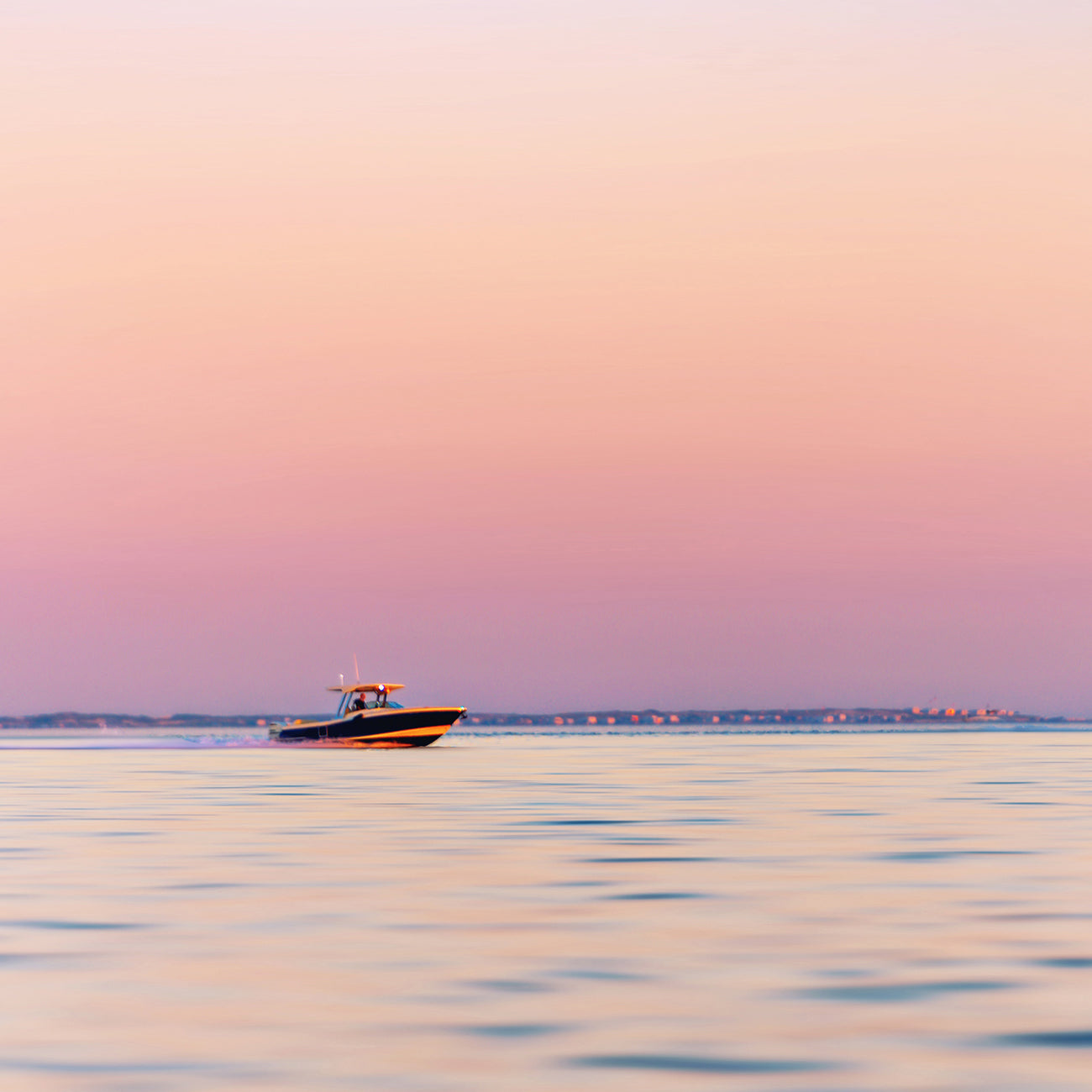 A picture of a boat in the ocean at sunset.