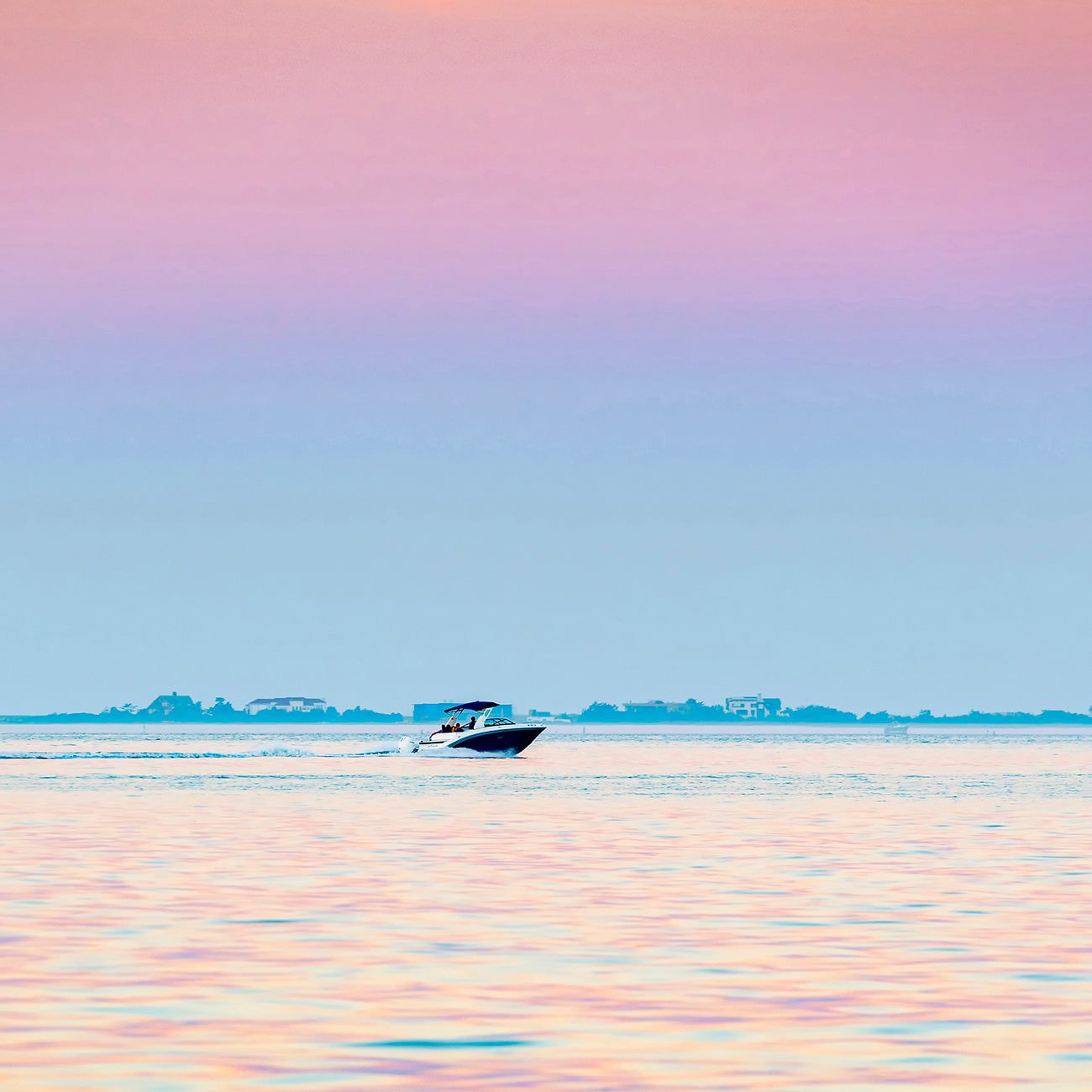 A picture of a boat in the ocean with a sunset in the background.