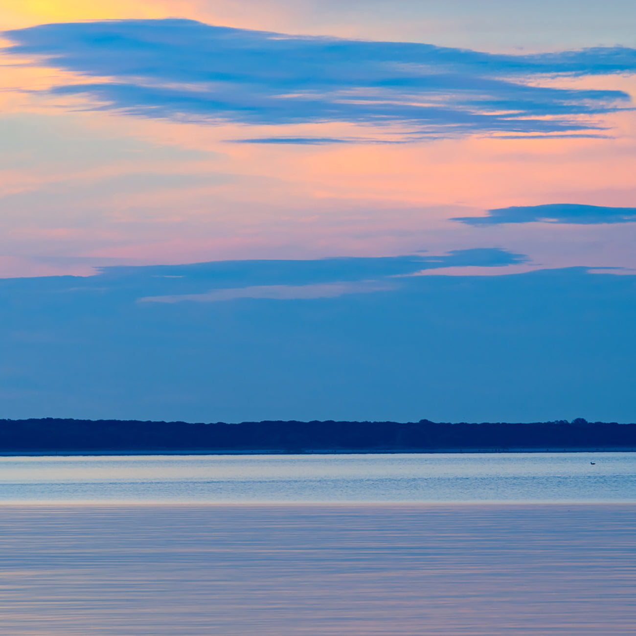 A set of three pictures of a sunset over a body of water.
