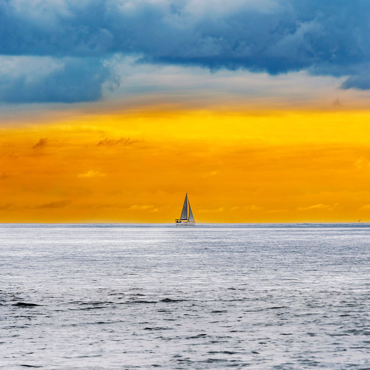 A picture of a sailboat in the ocean and a plane flying in the sky.