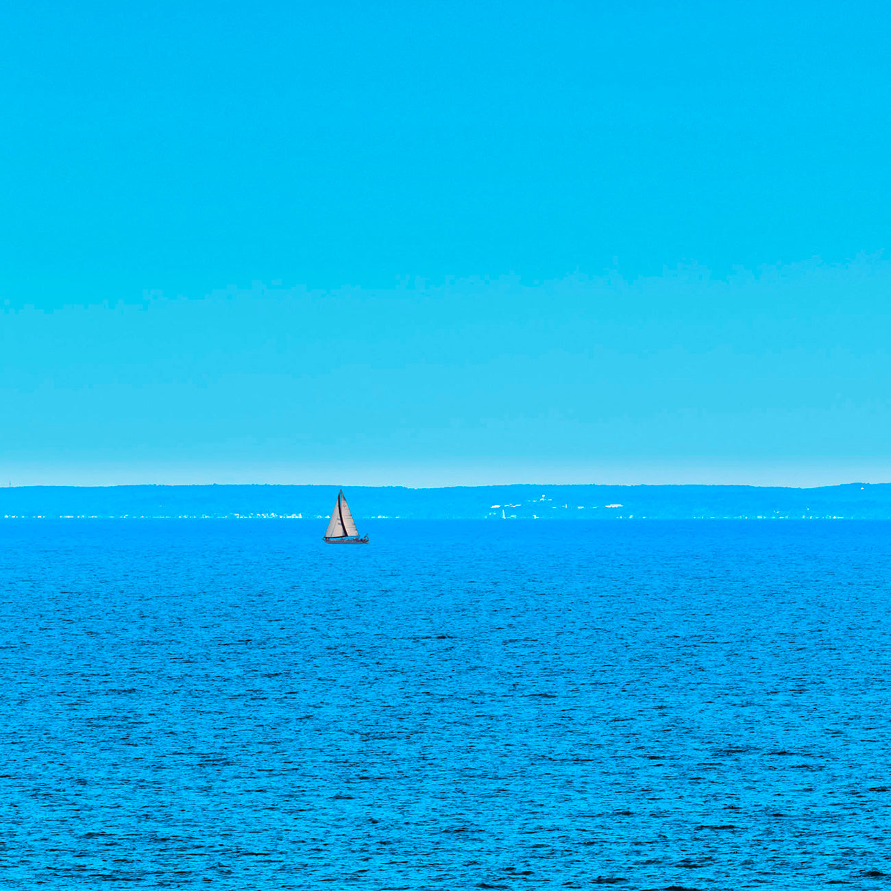 Two pictures of a sailboat in the ocean and a cloud in the sky.