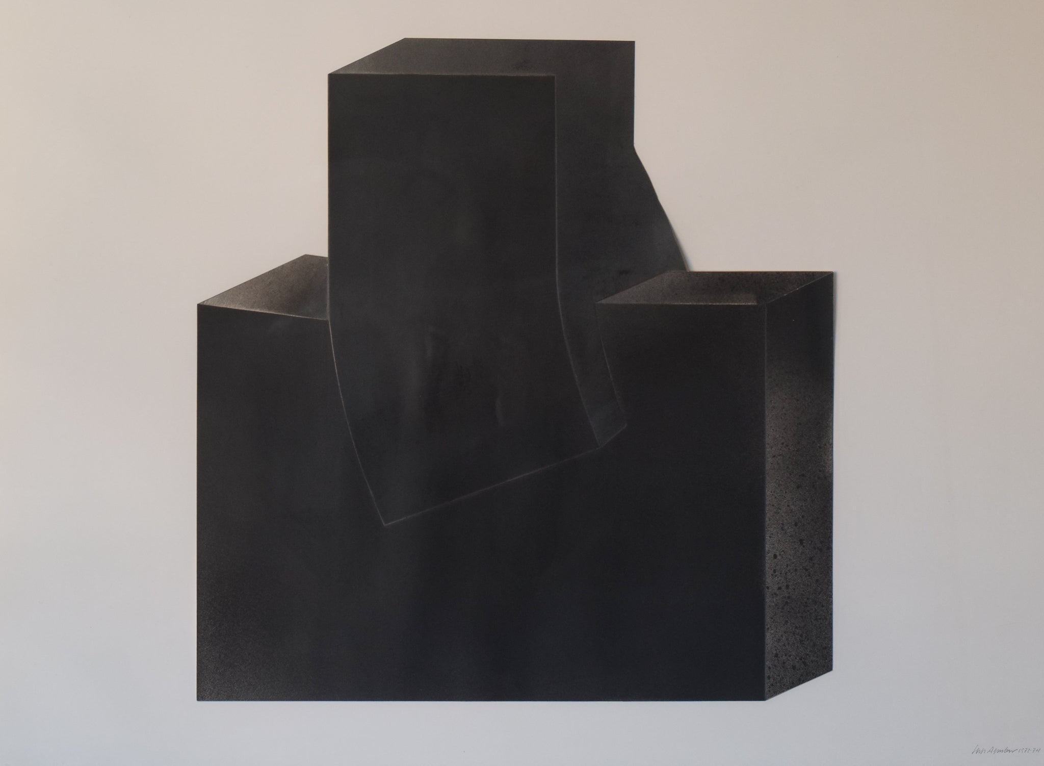 A black sculpture on a white wall in a room.