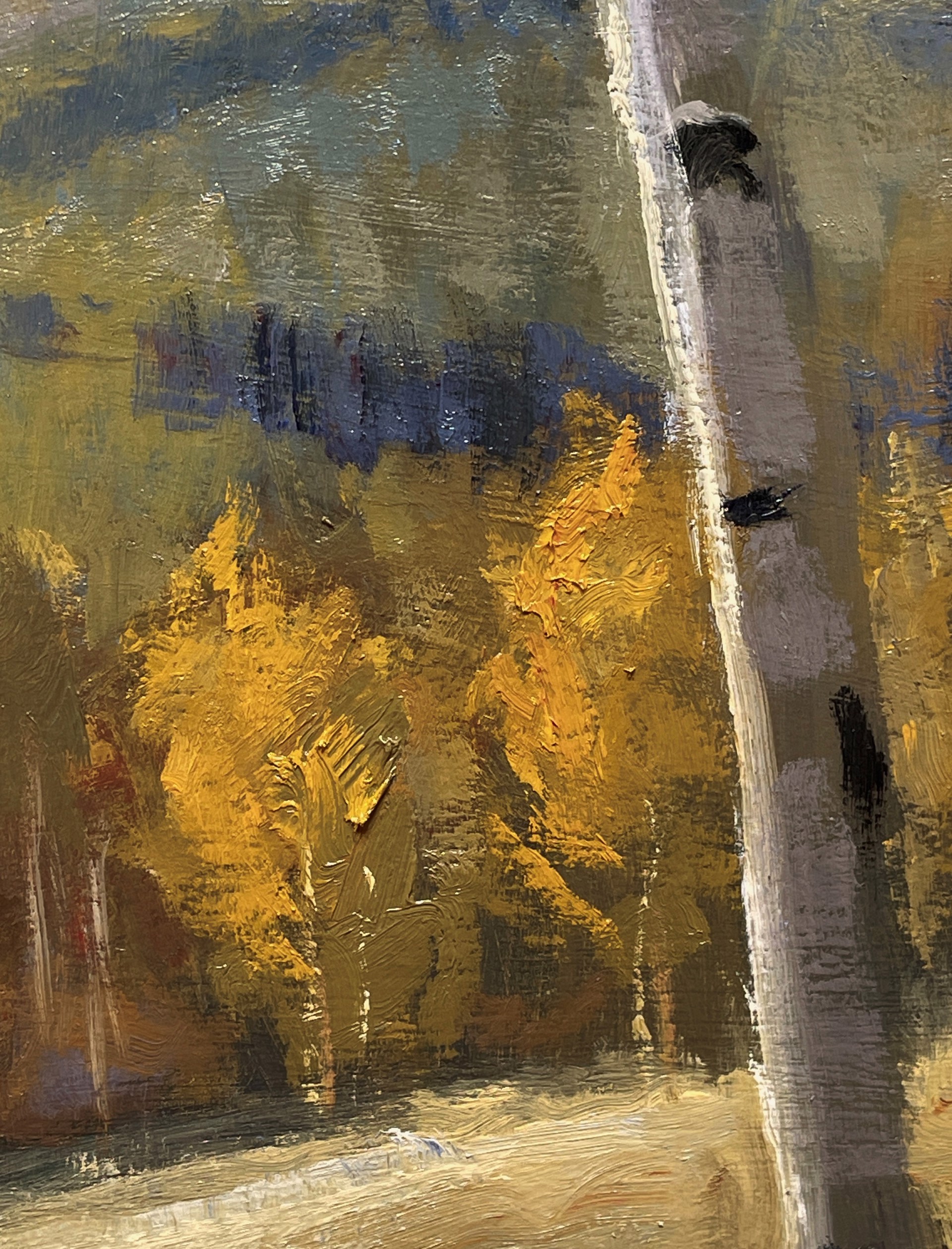 A serene autumn landscape featuring a winding path through golden aspen trees under a dramatic blue sky.