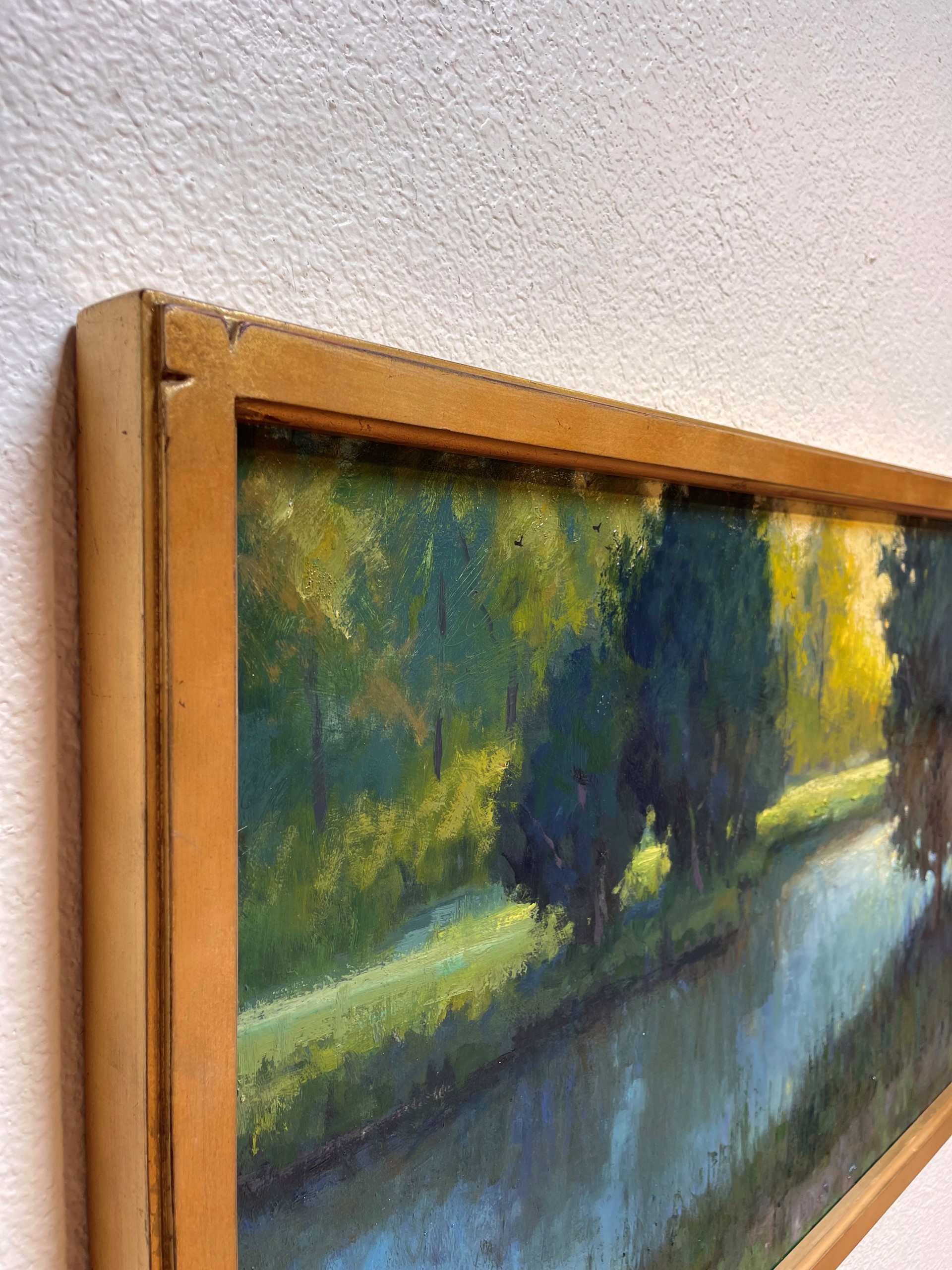 A painting of a lake with trees in the background.