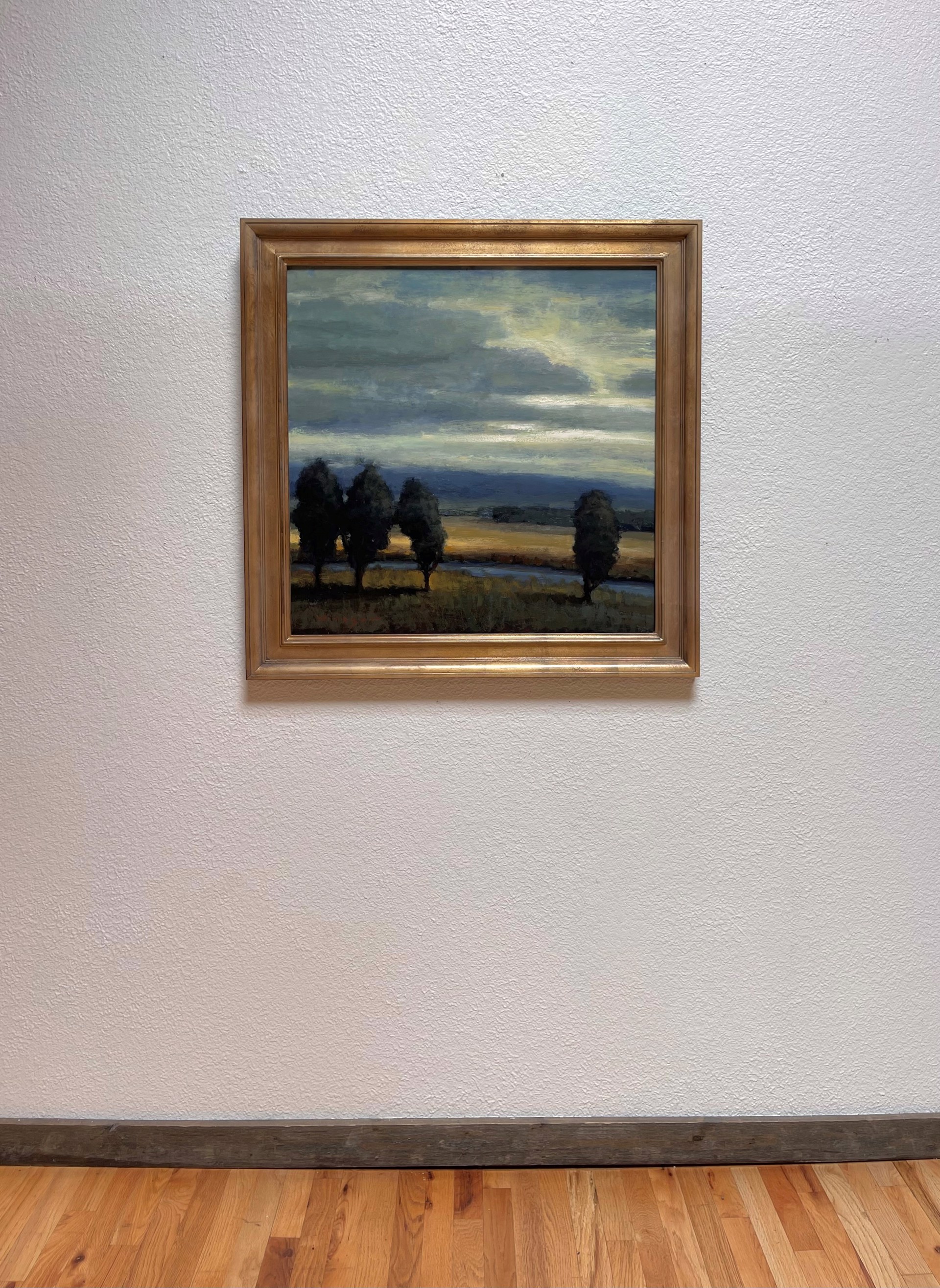 A painting of three trees in a field at sunset.