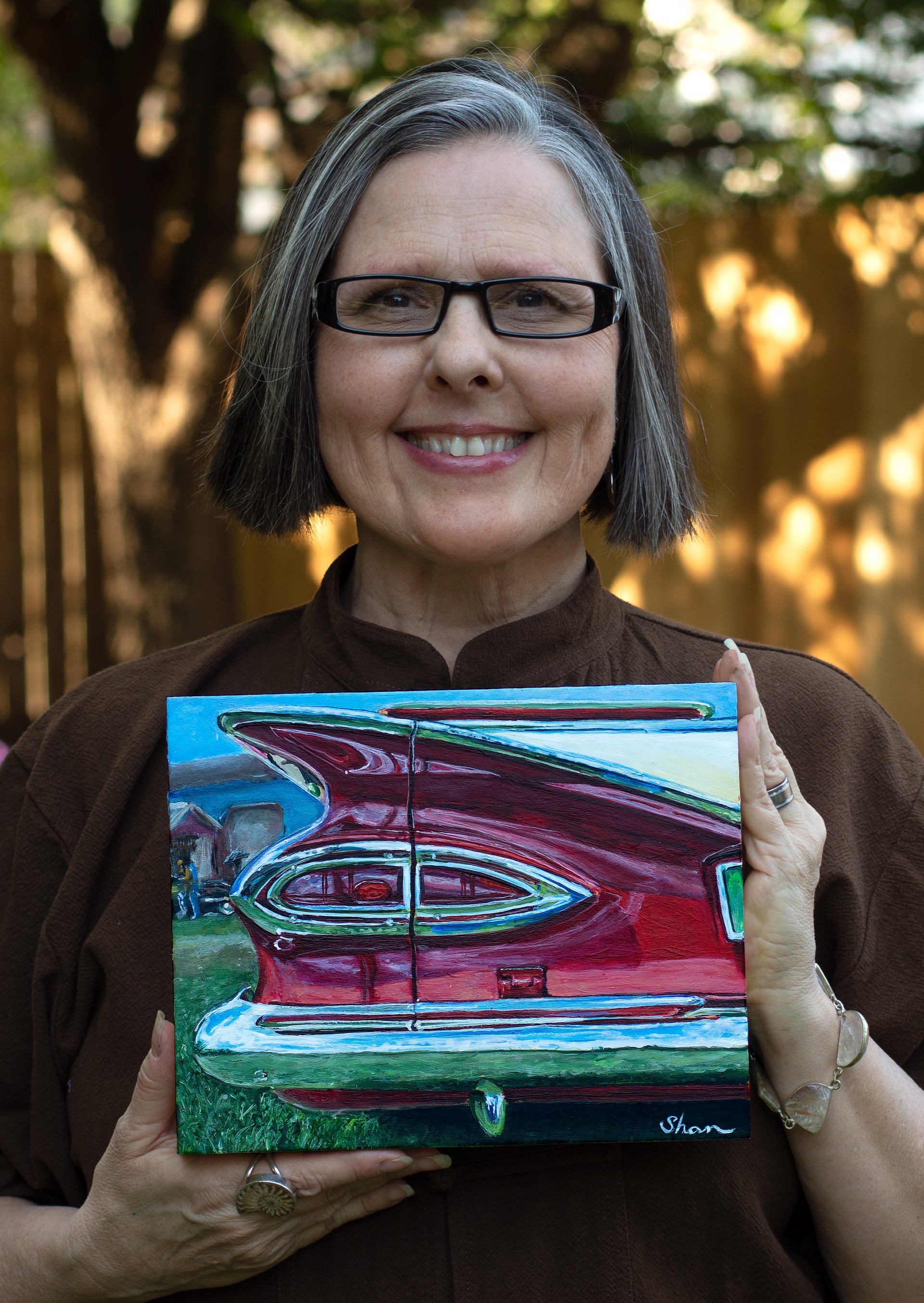 A painting of a red car parked in a field.