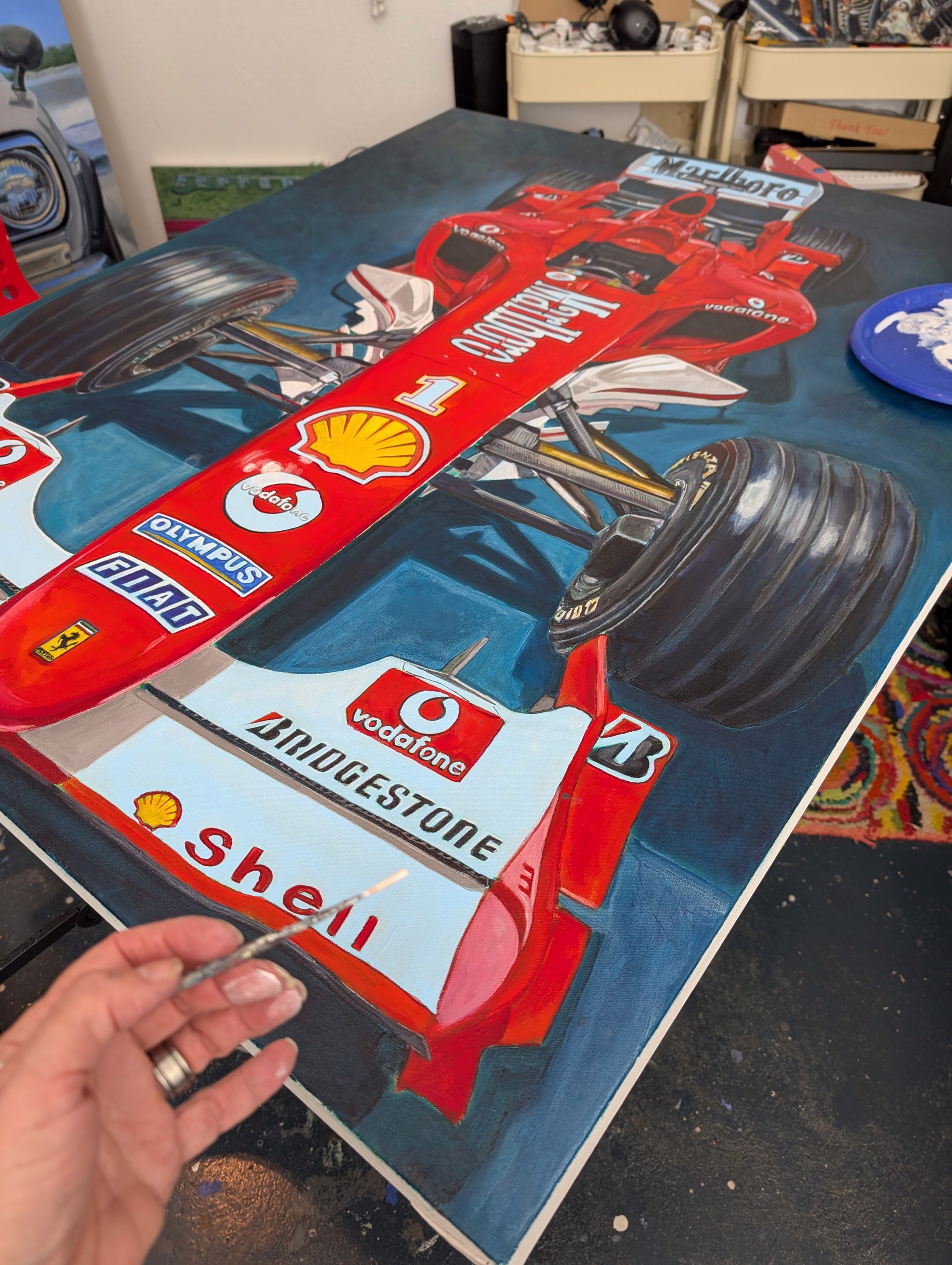 A detailed painting of a Formula One race car viewed from the front.